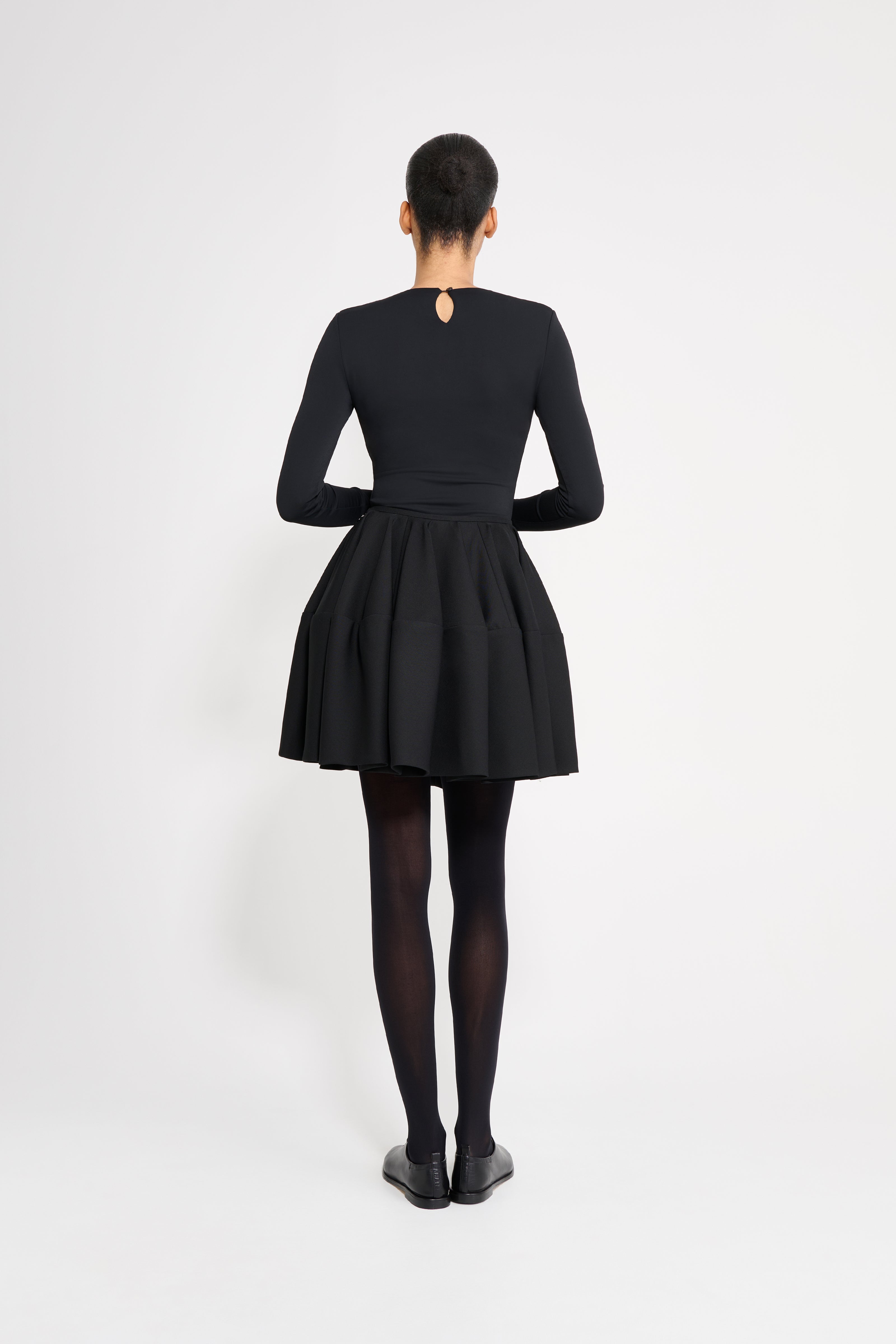 Person wearing a black dress on a white background