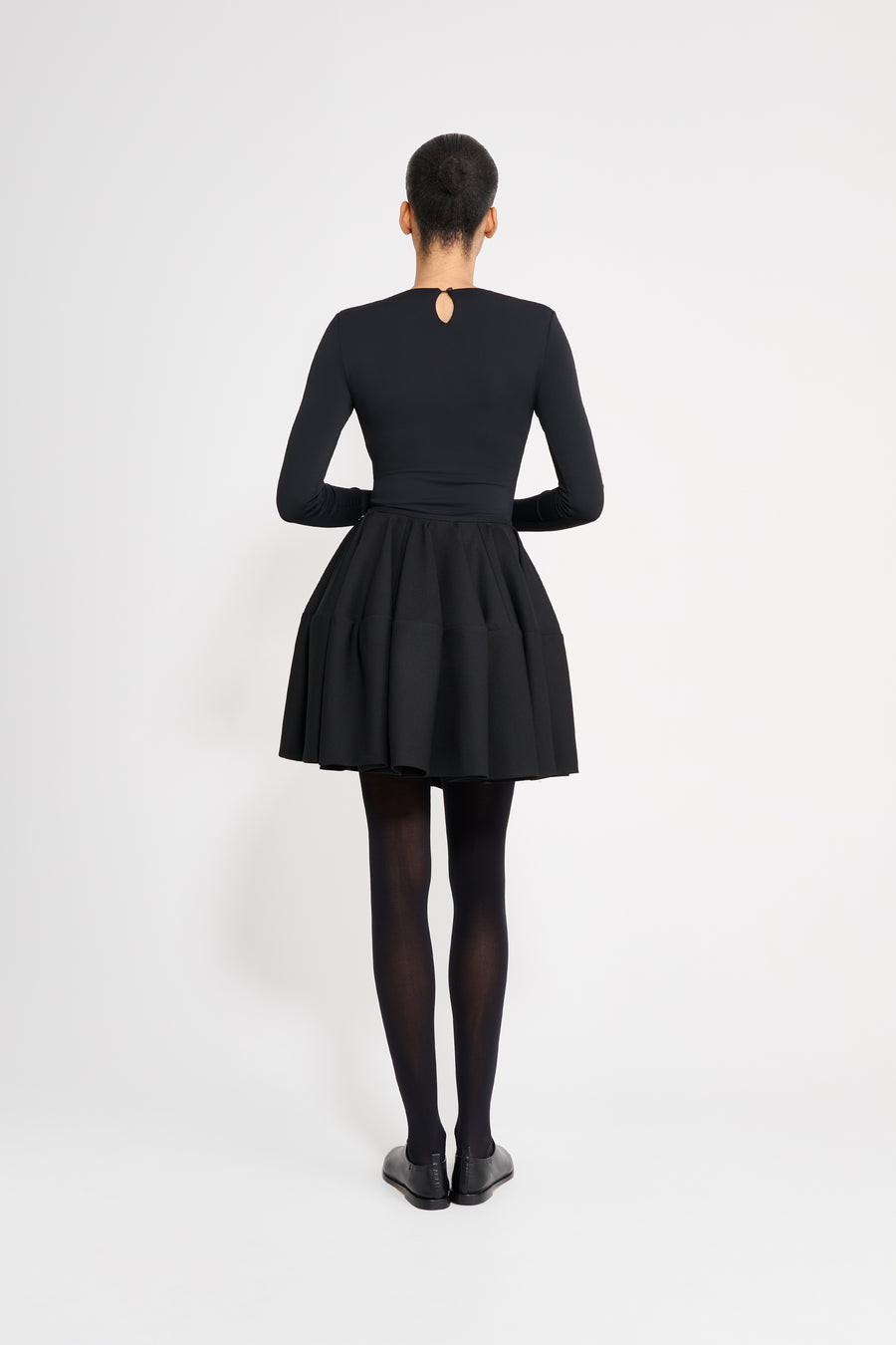 Person wearing a black dress on a white background