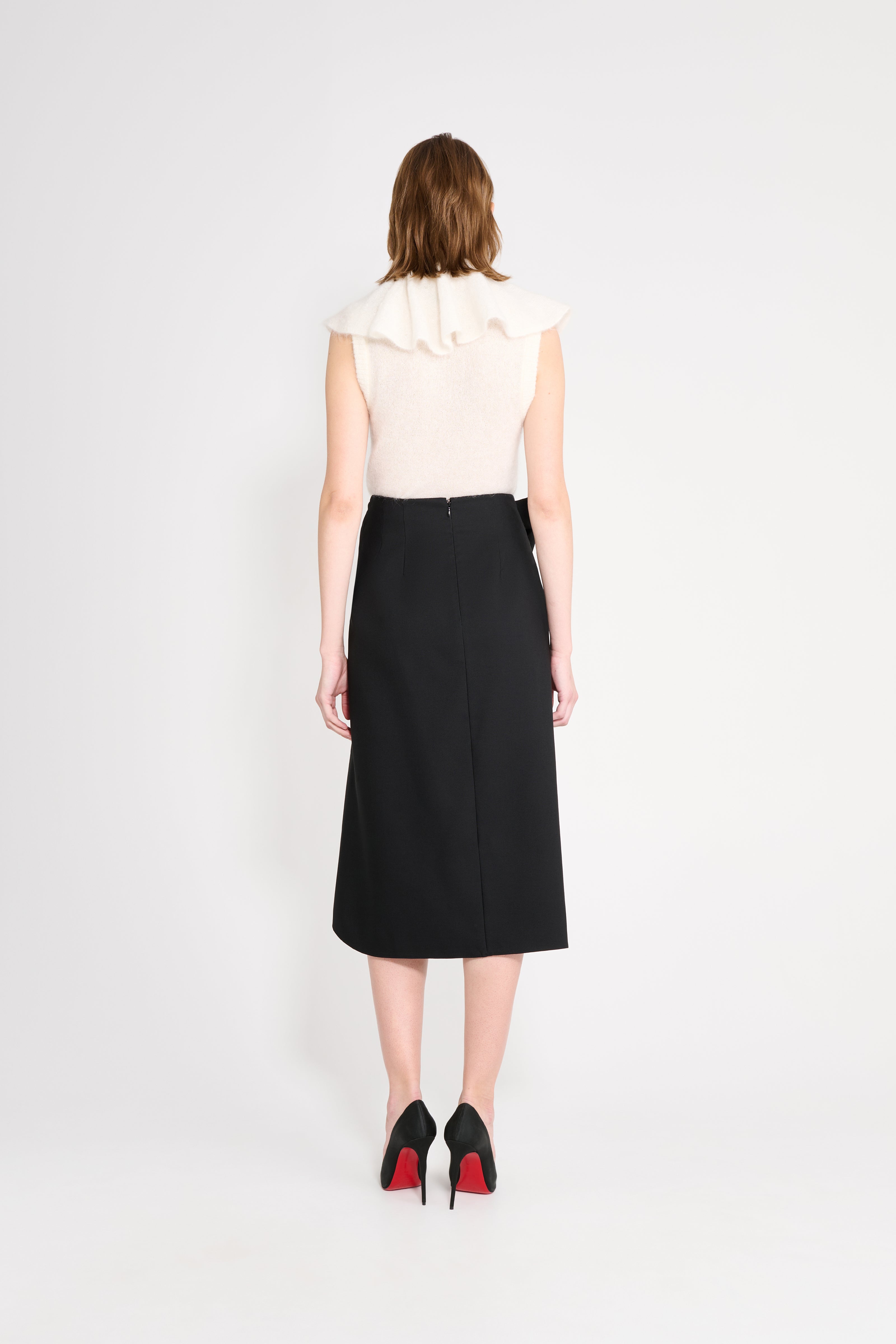 Model wearing a black wool skirt shown from the back.