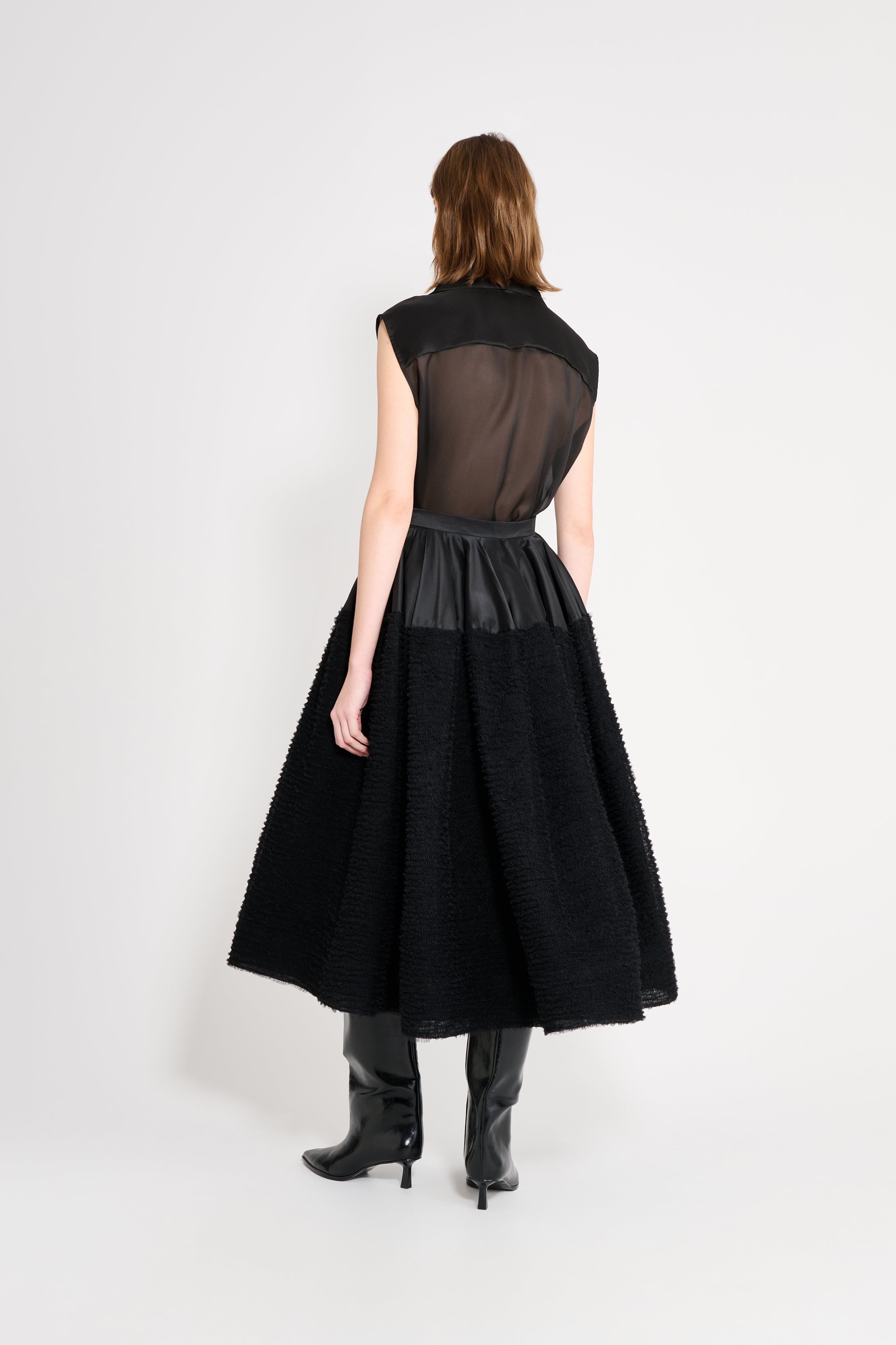 Black dress with sheer overlay on a white background