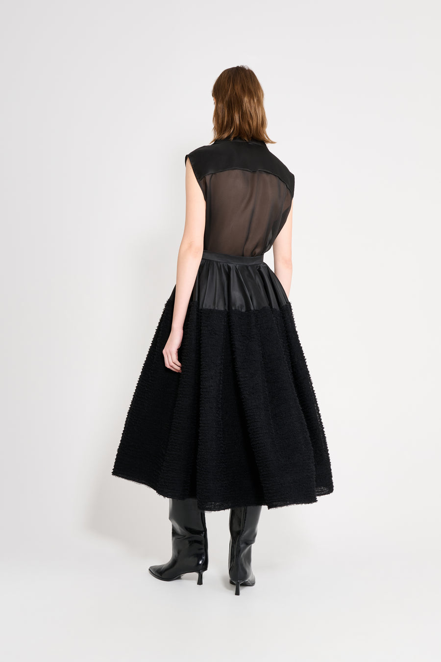 Black dress with sheer overlay on a white background