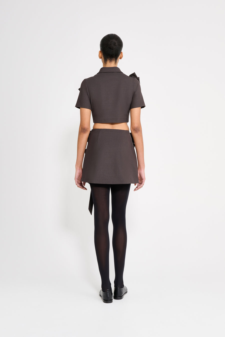 The wool skirt features the seasonal bow bouquet technique, where timeless elegance meets refined craftsmanship in a seamless fusion of sophistication and grace