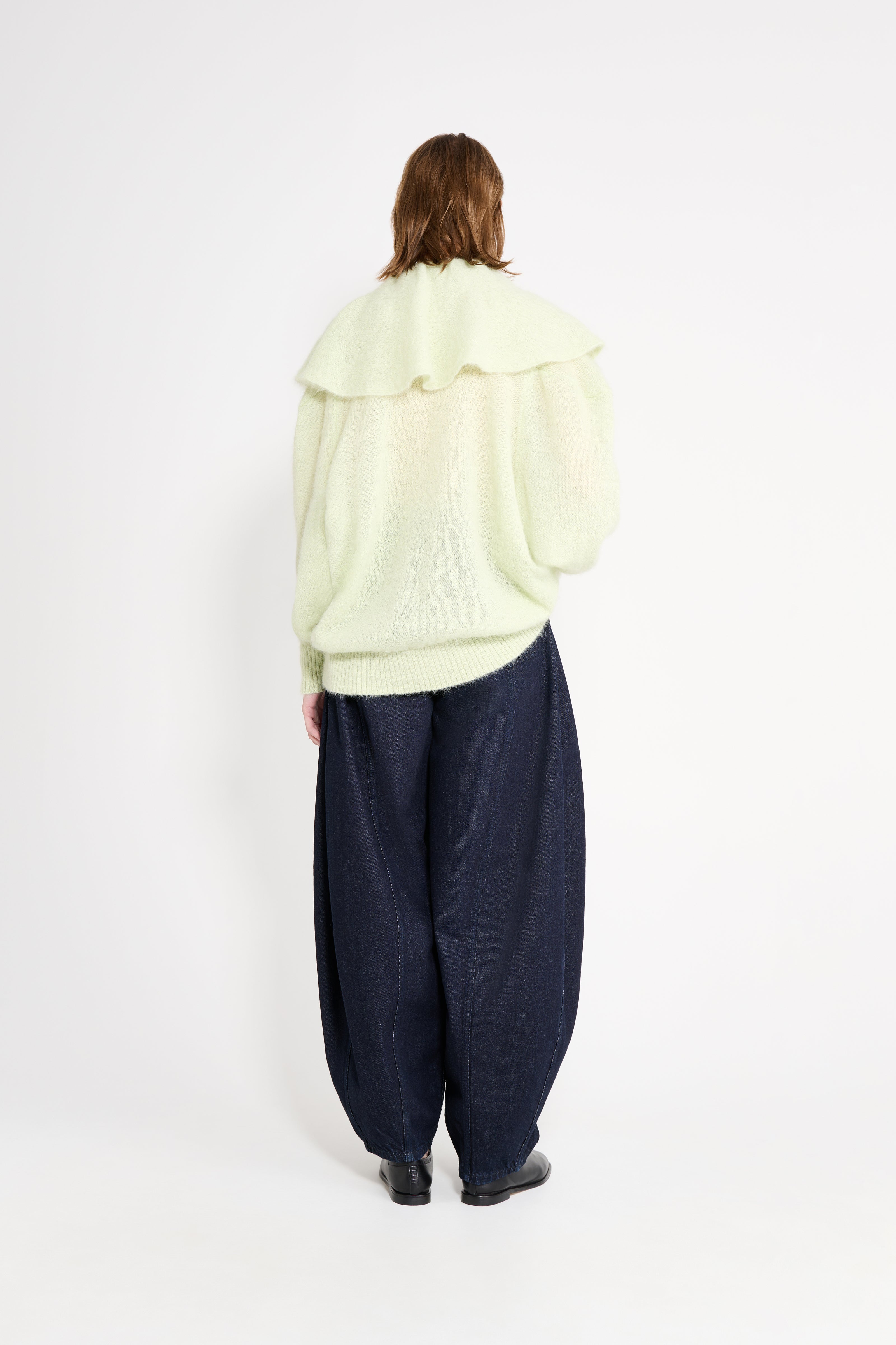 Model wearing  mint volant sweater shown from the back.