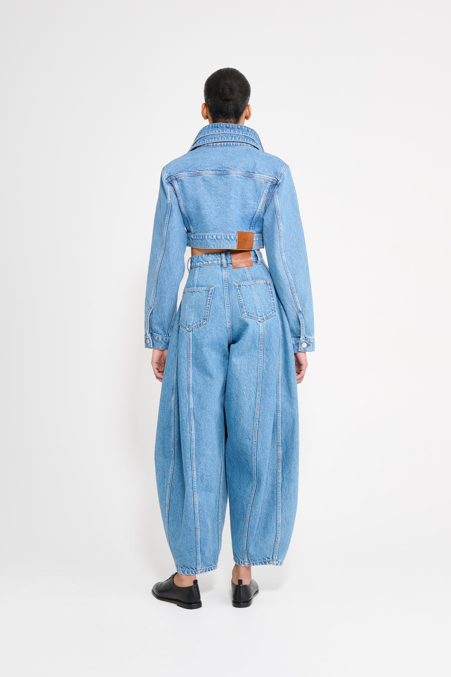 Person wearing a blue denim outfit on a white background