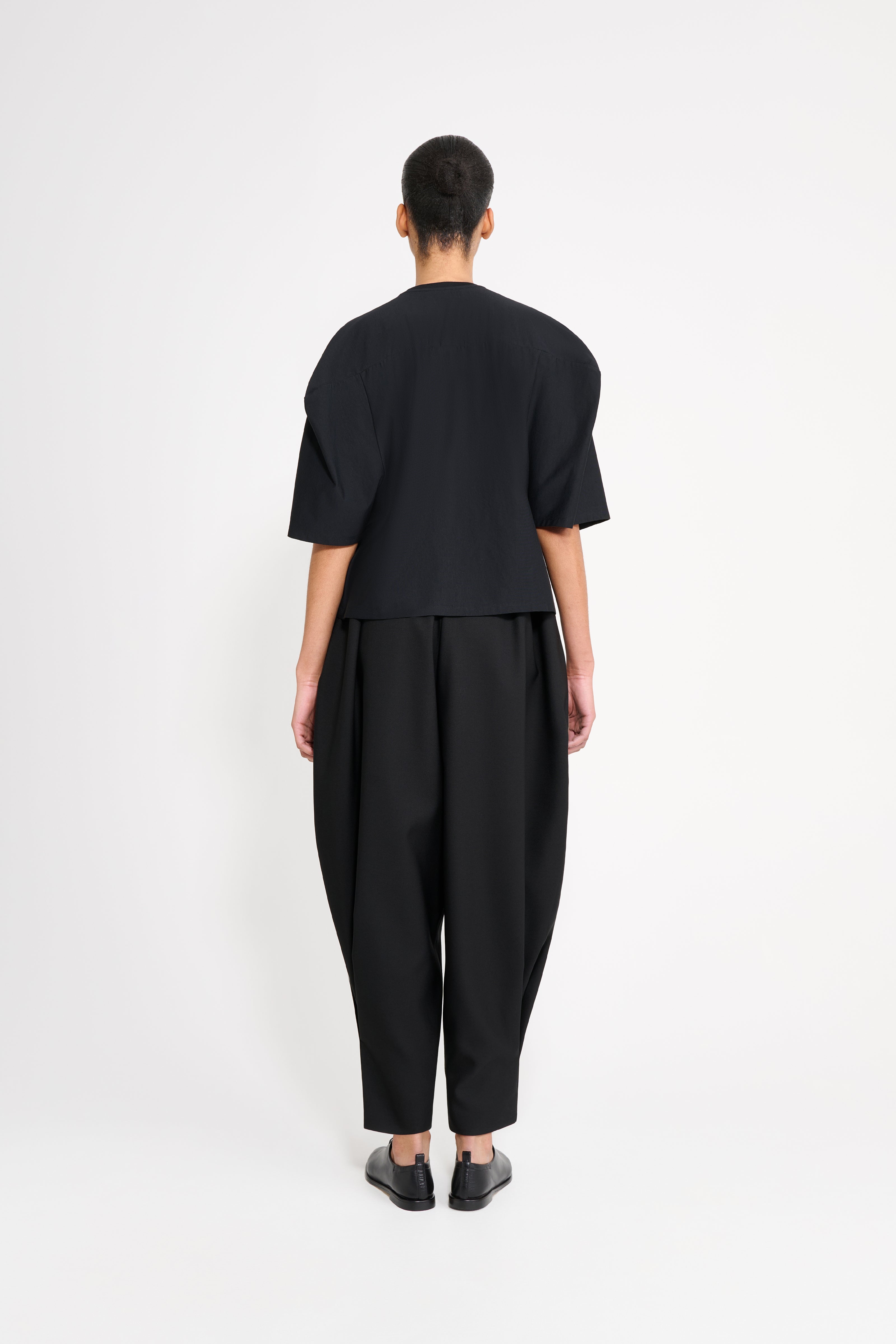 Person wearing a black outfit on a white background