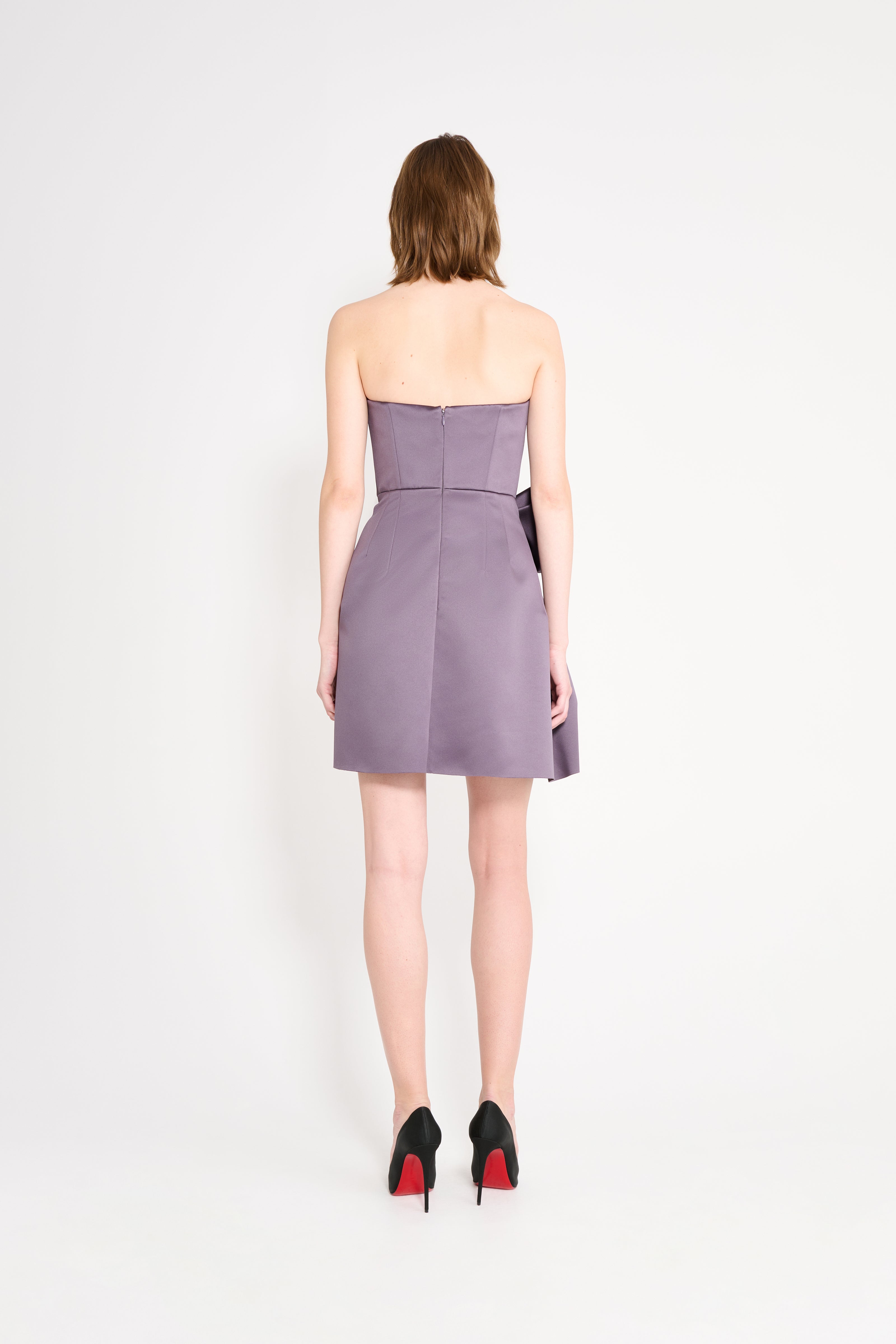 Model wearing a purple mini dress on a white background.