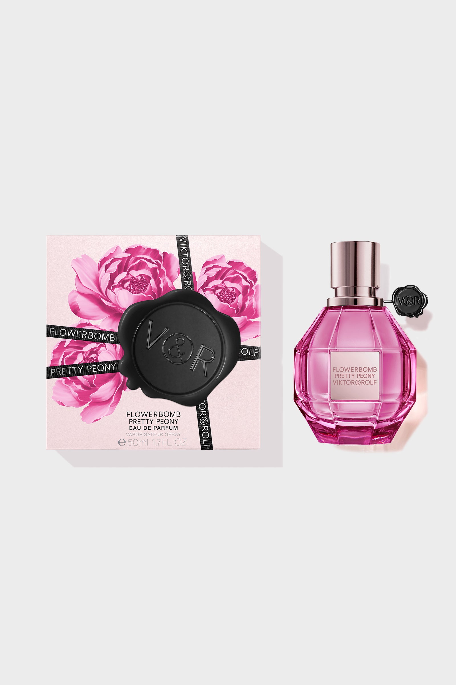 Pretty Peony Flowerbomb perfume in a pink bottle with a box next to it on a white background.