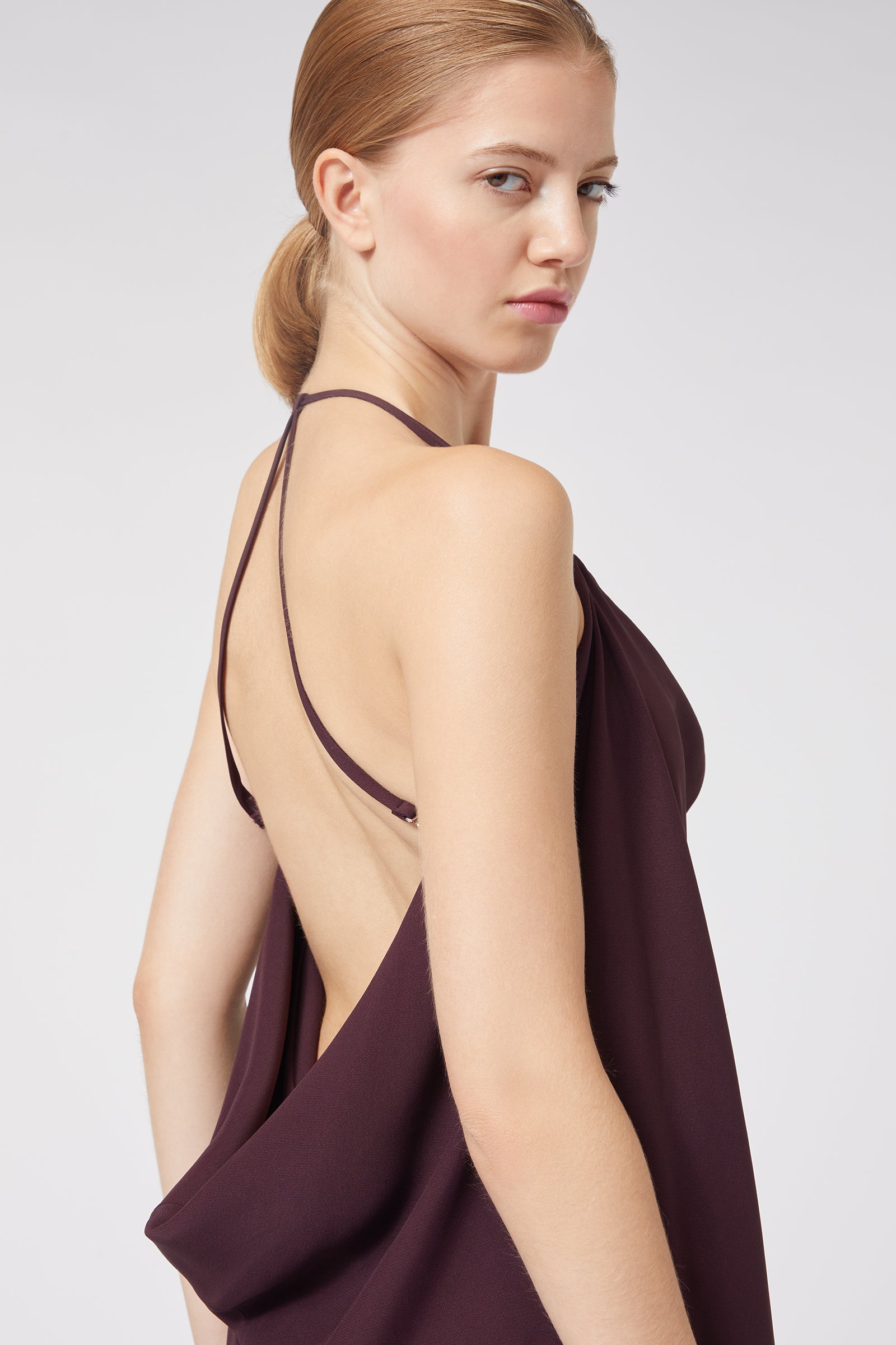 Backless dress with delicate spaghetti straps in deep plum, softly draping for an elegant and sophisticated look.