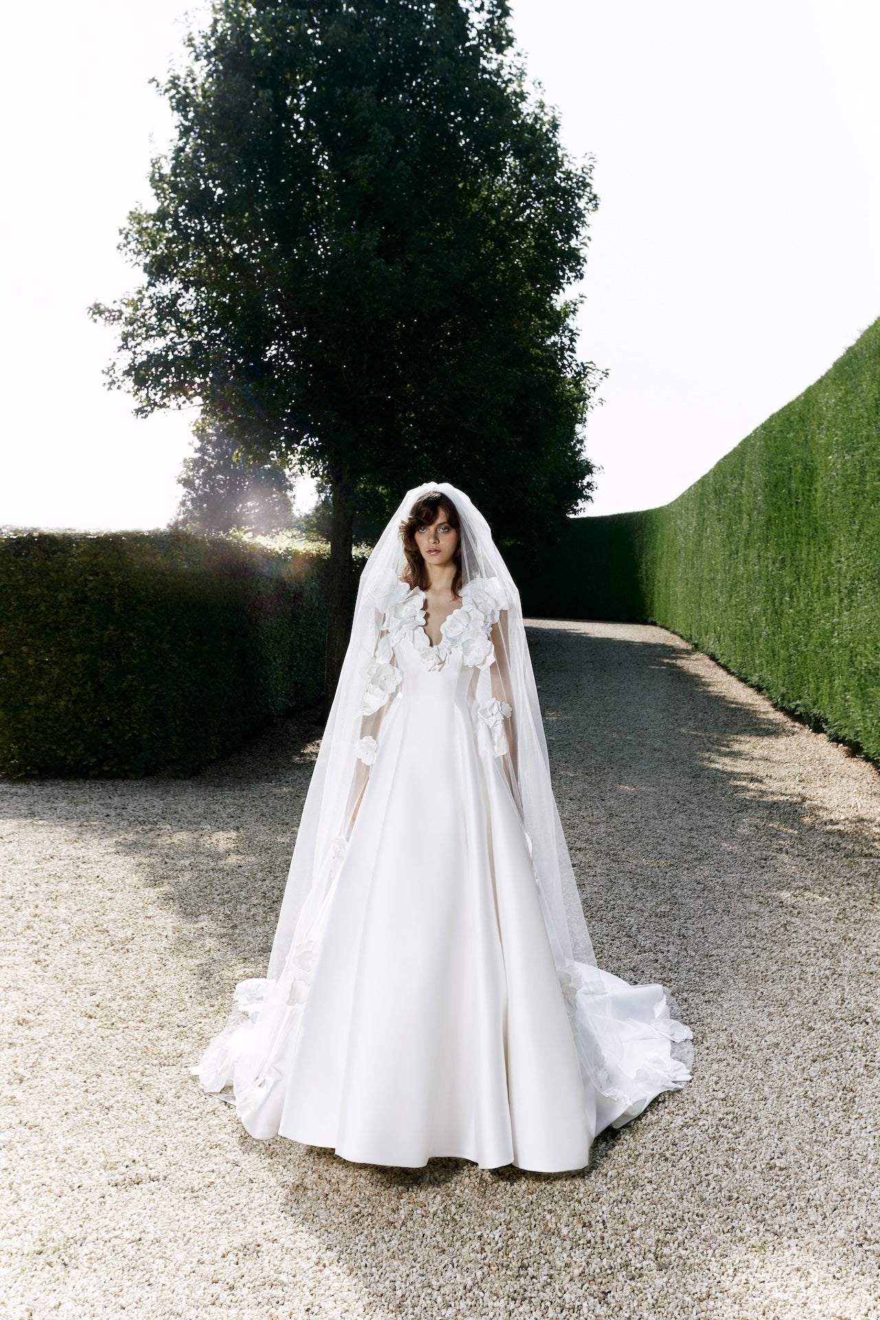Viktor & Rolf Mariage Bridalwear Collection, Autumn Winter 25, elegant gown with floral appliqués and flowing veil.