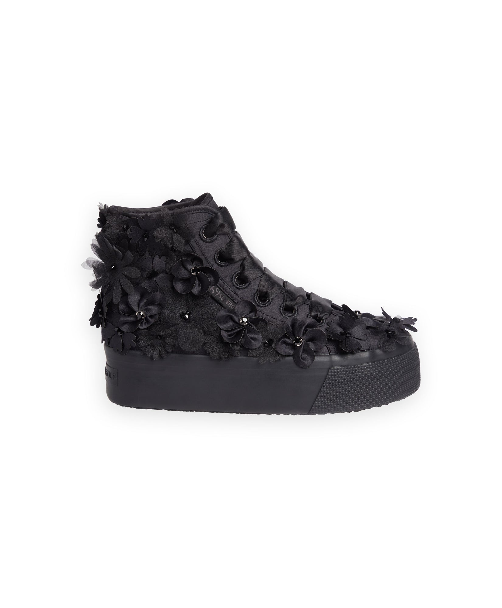 Black platform sneaker adorned with intricate floral appliqués and fabric textures, showcasing unique, detailed craftsmanship.