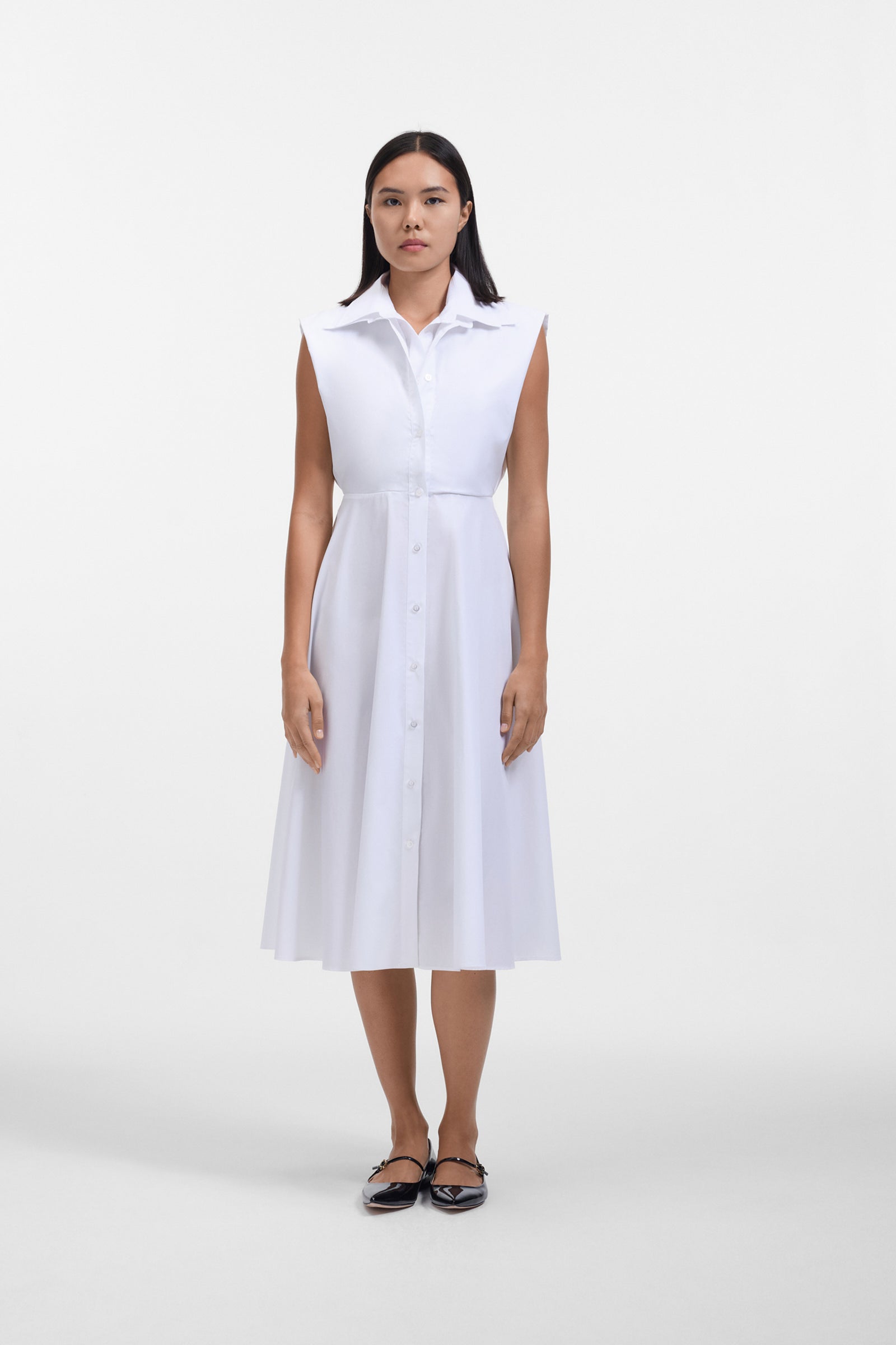Model wearing a white shirt dress with a multi-layer collar on a withe background.