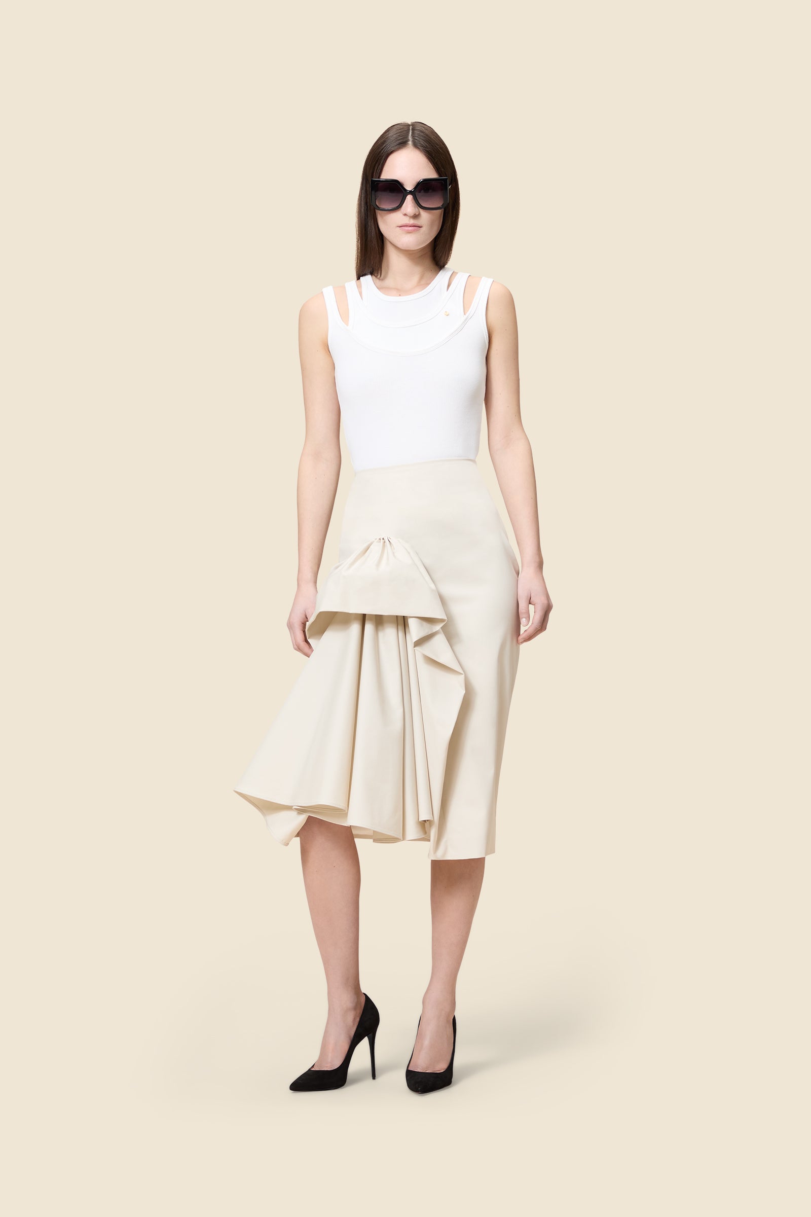 The craftmanship of the skirt reinterprets classic haute couture tuck ups into a modern silhouette from gabardine