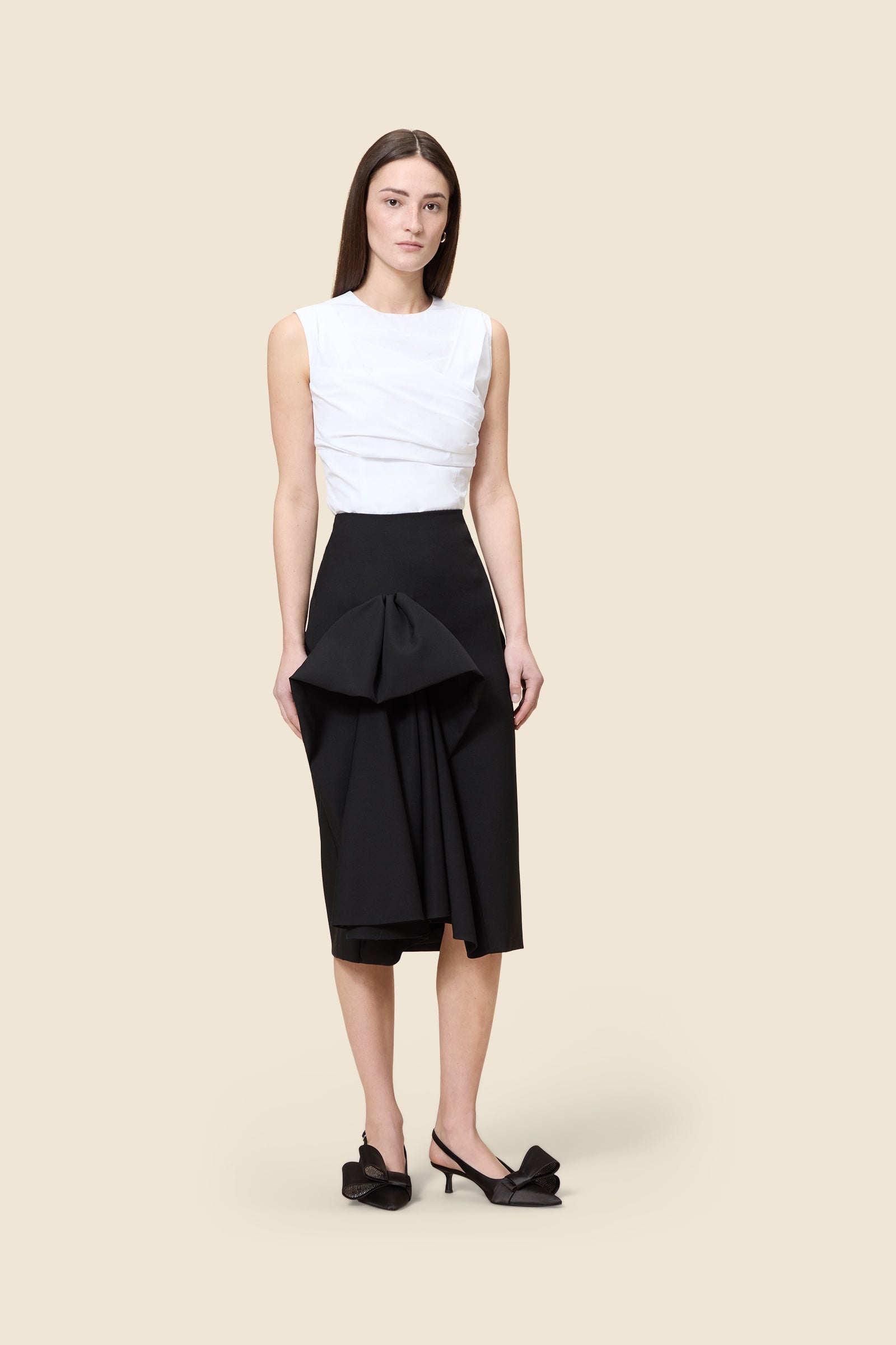 The craftmanship of the skirt reinterprets classic haute couture tuck ups into a modern silhouette from wool