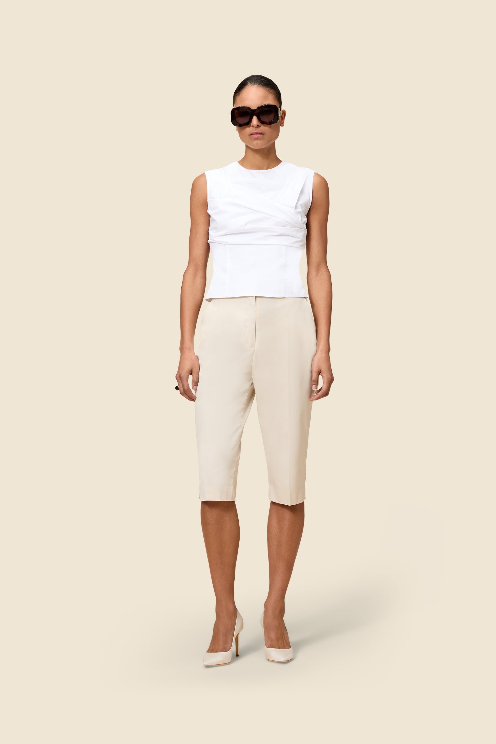 Crafted from gabardine, the high-waisted capri pants offer a tailored fit and timeless elegance