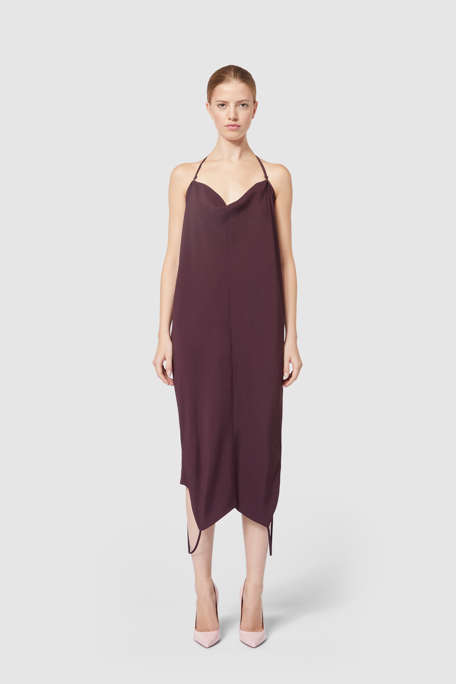 Sleeveless plum slip dress with a cowl neckline and asymmetrical hem, complemented by spaghetti straps for a sleek look.