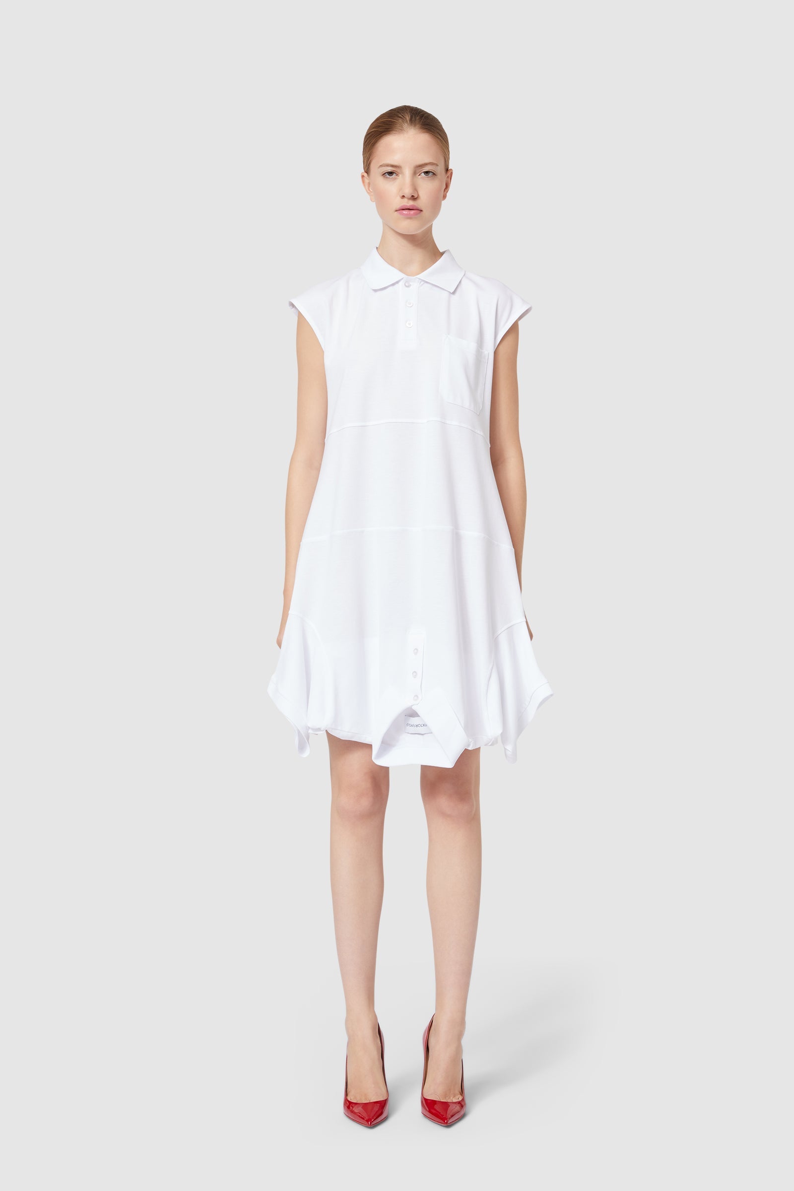 A white A-line dress featuring a classic collar and sleeveless design, styled with striking red high heels.