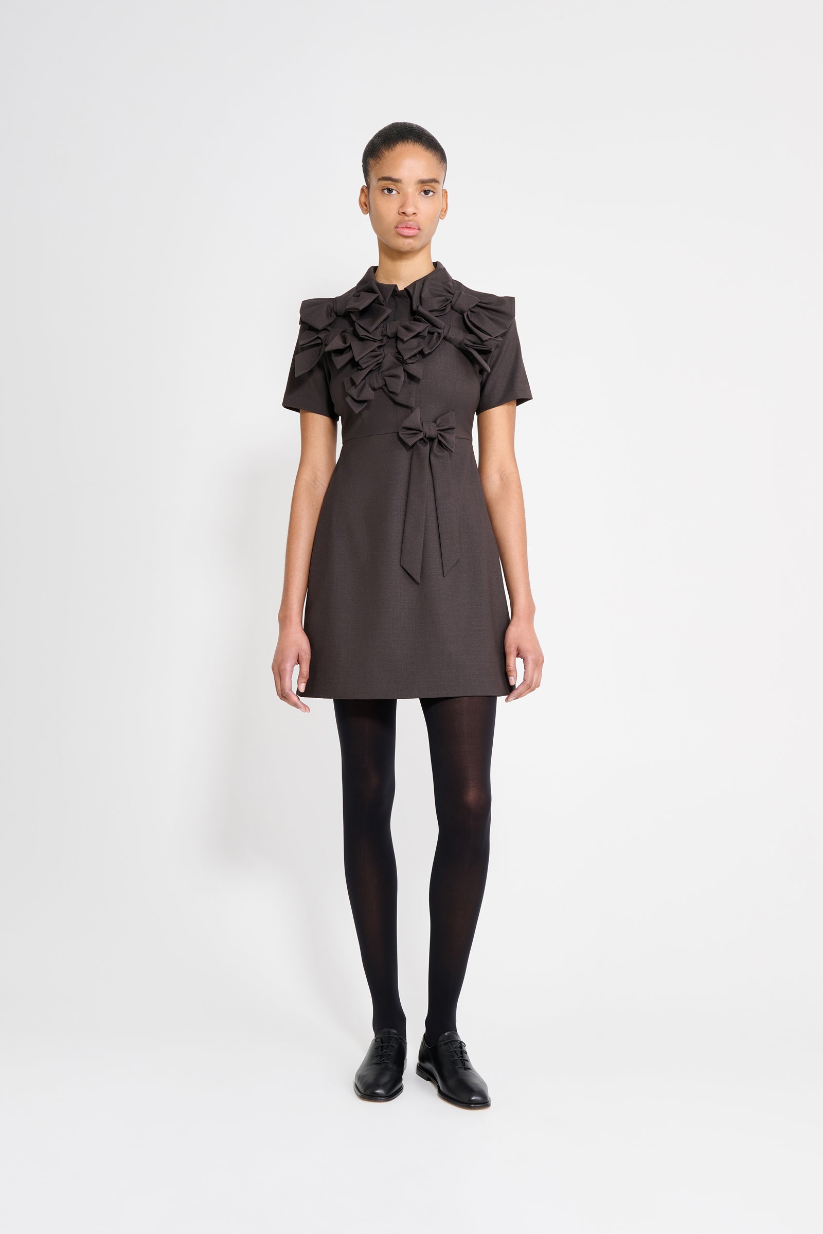The wool dress features the seasonal bow bouquet technique, where timeless elegance meets refined craftsmanship in a seamless fusion of sophistication and grace