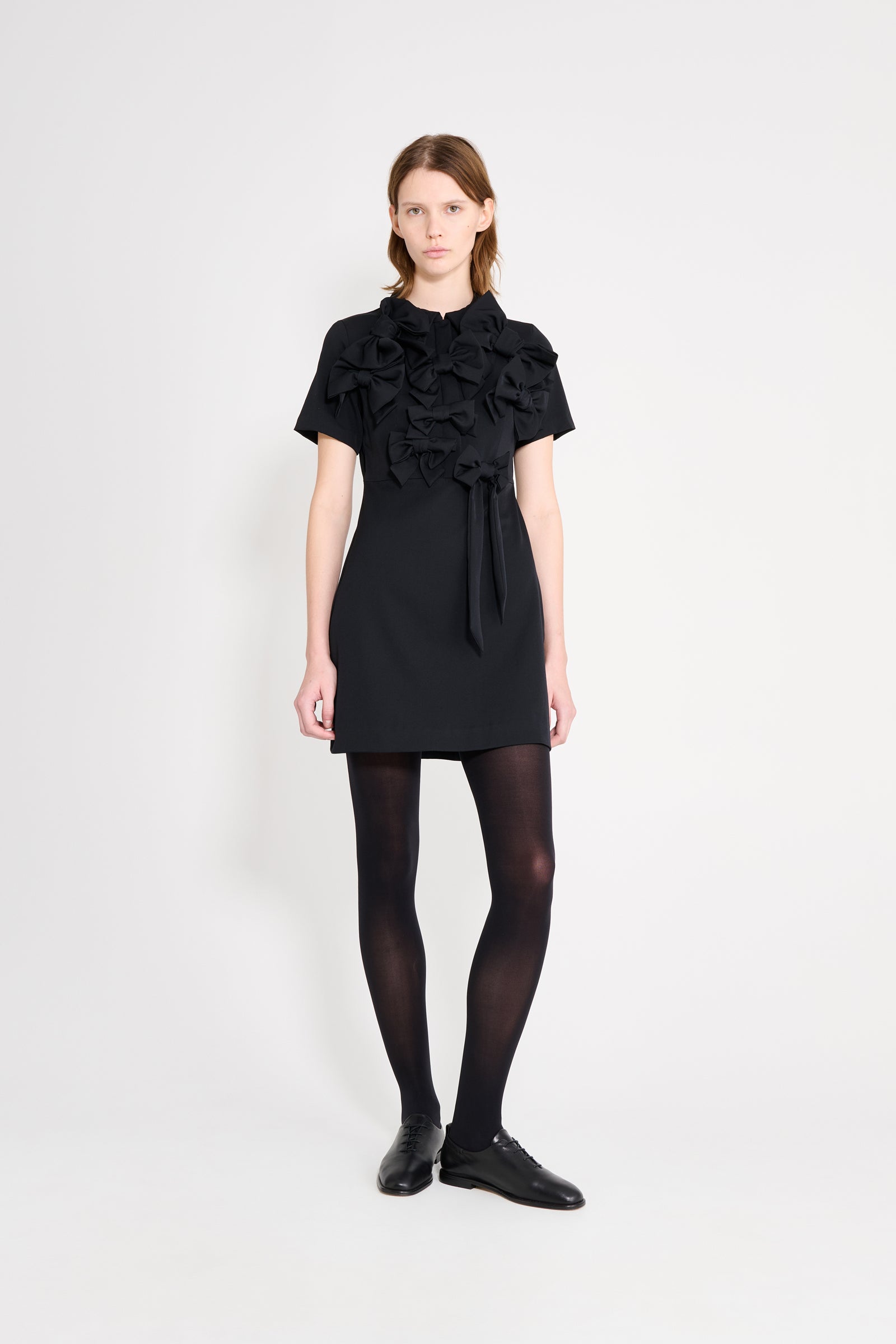 The wool dress features the seasonal bow bouquet technique, where timeless elegance meets refined craftsmanship in a seamless fusion of sophistication and grace