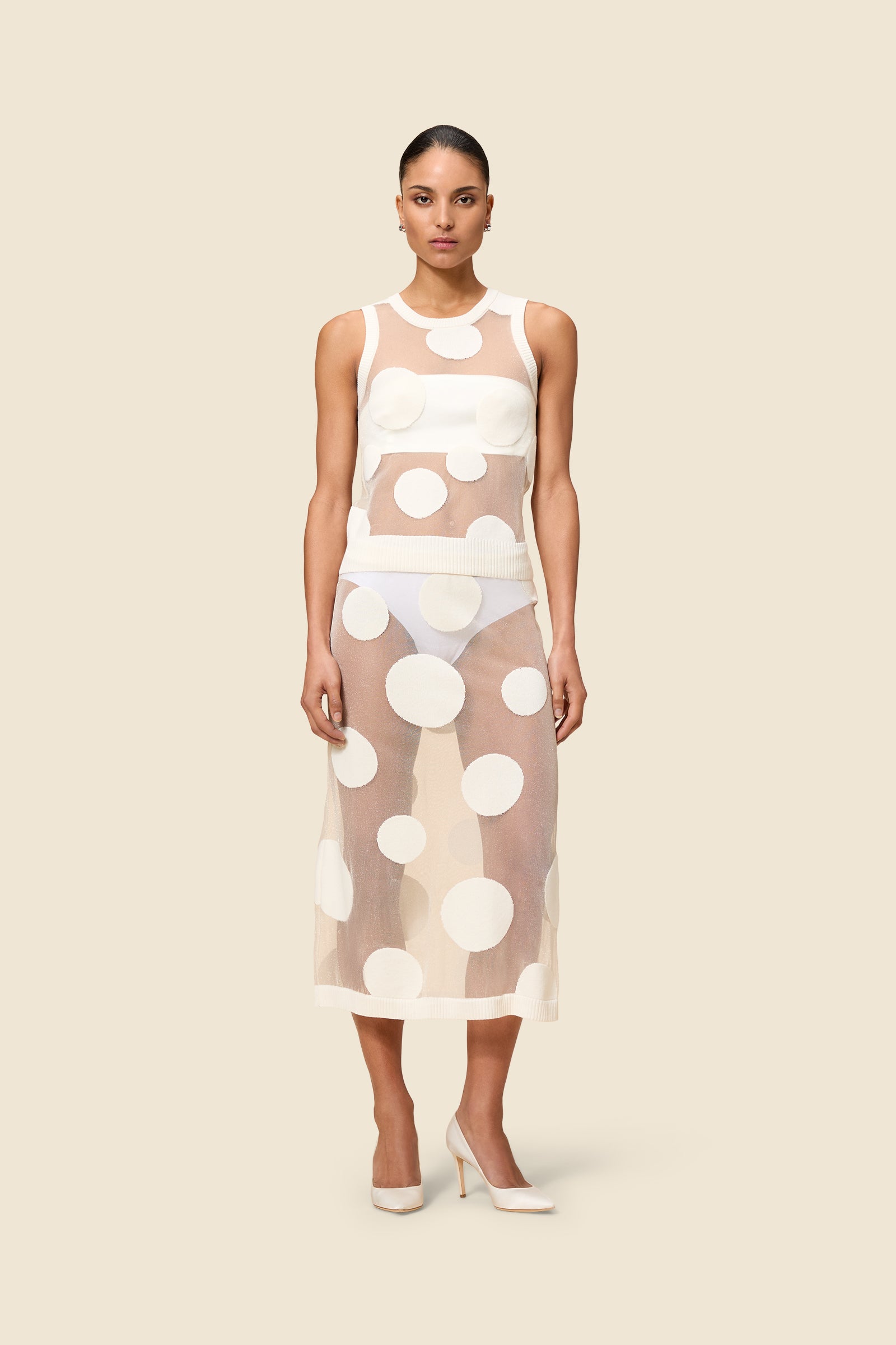 The classic pattern of the skirt is given a modern twist with intricate polka dot hole design on knit jacquard