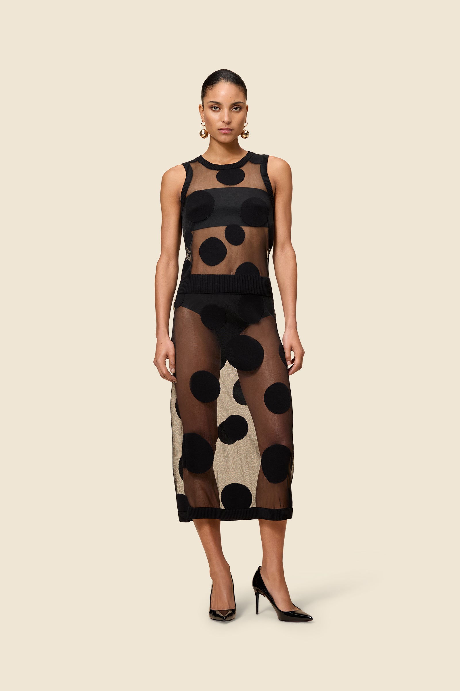 The classic pattern of the skirt is given a modern twist with intricate polka dot hole design on knit jacquard