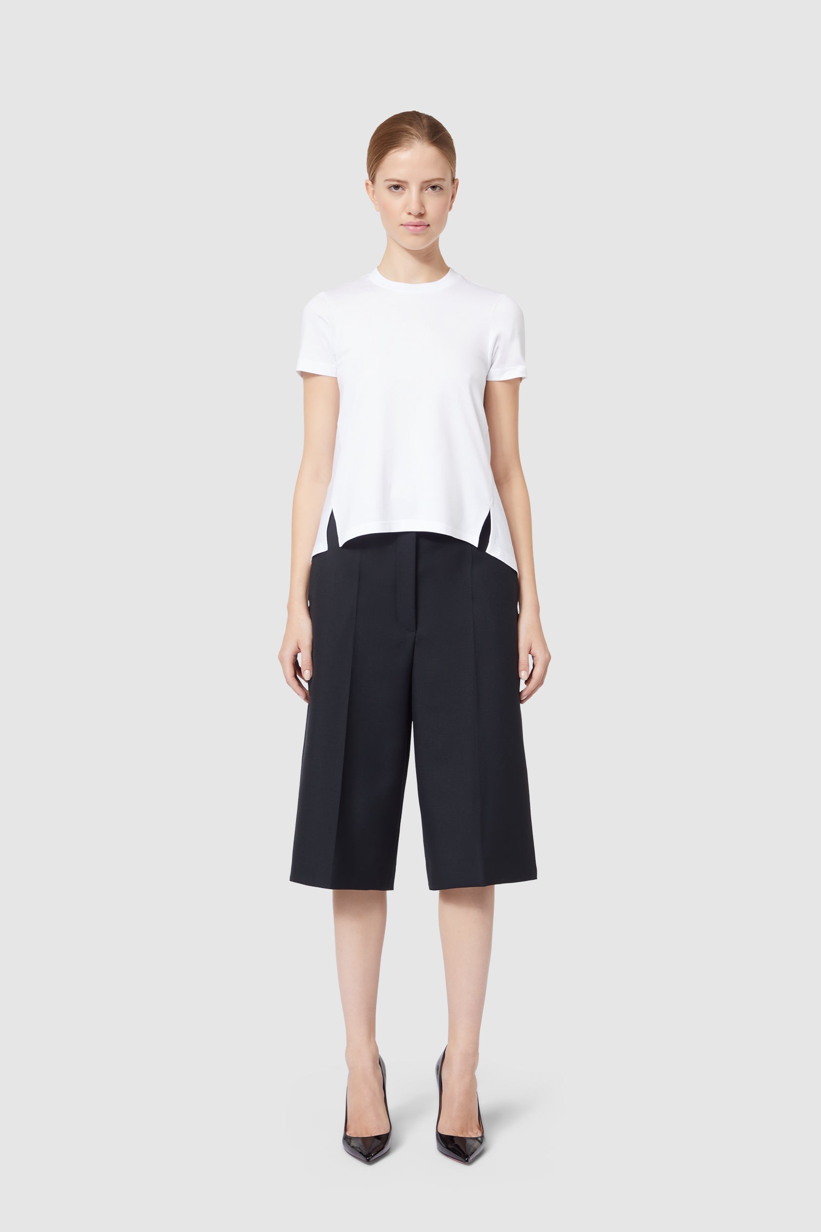 Elegant black culottes and fitted white top ensemble, showcasing sophisticated tailoring and a modern minimalist design.