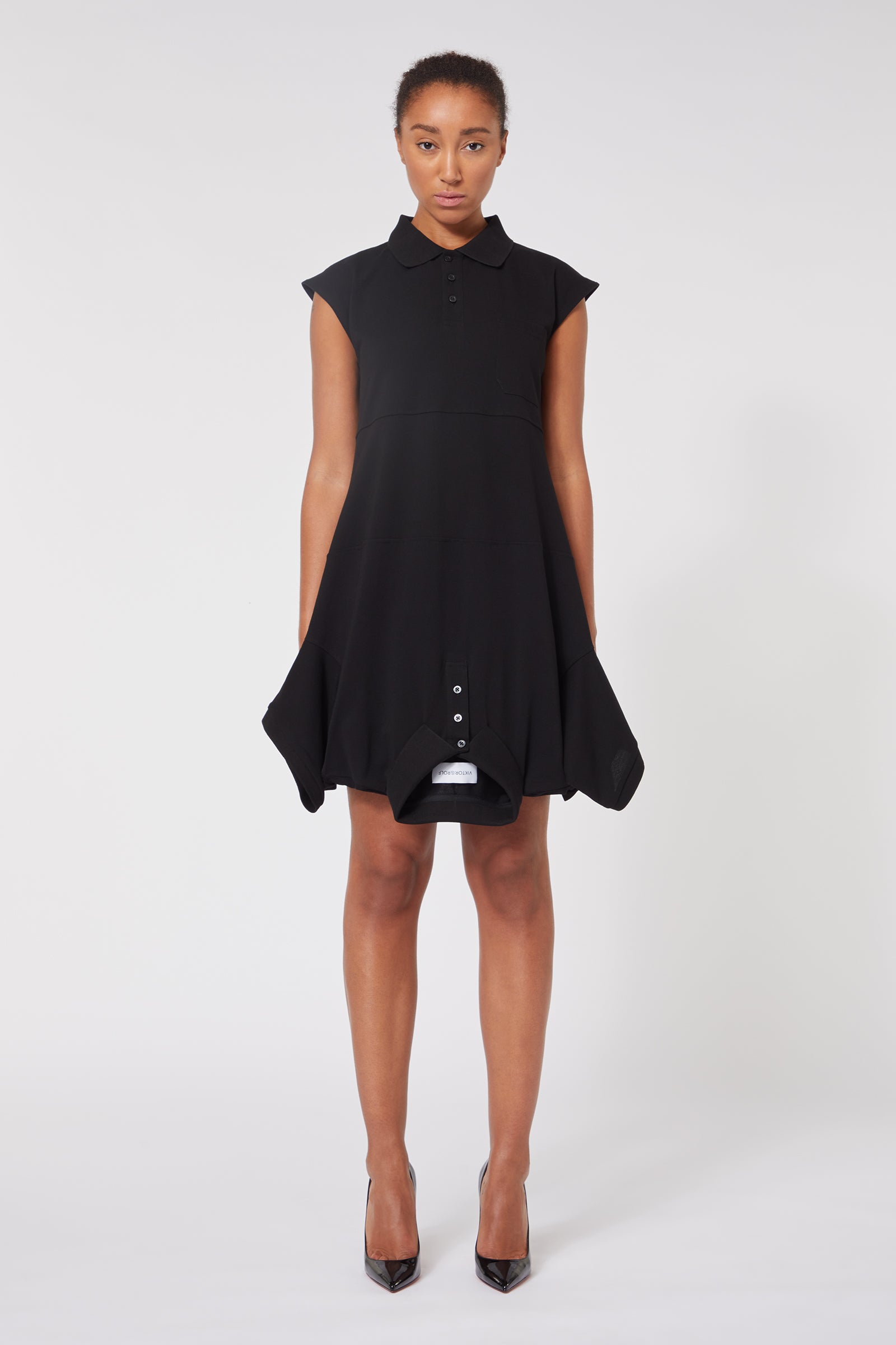 Elegant black A-line dress with cap sleeves and buttoned detail, showcasing a flattering, stylish silhouette.