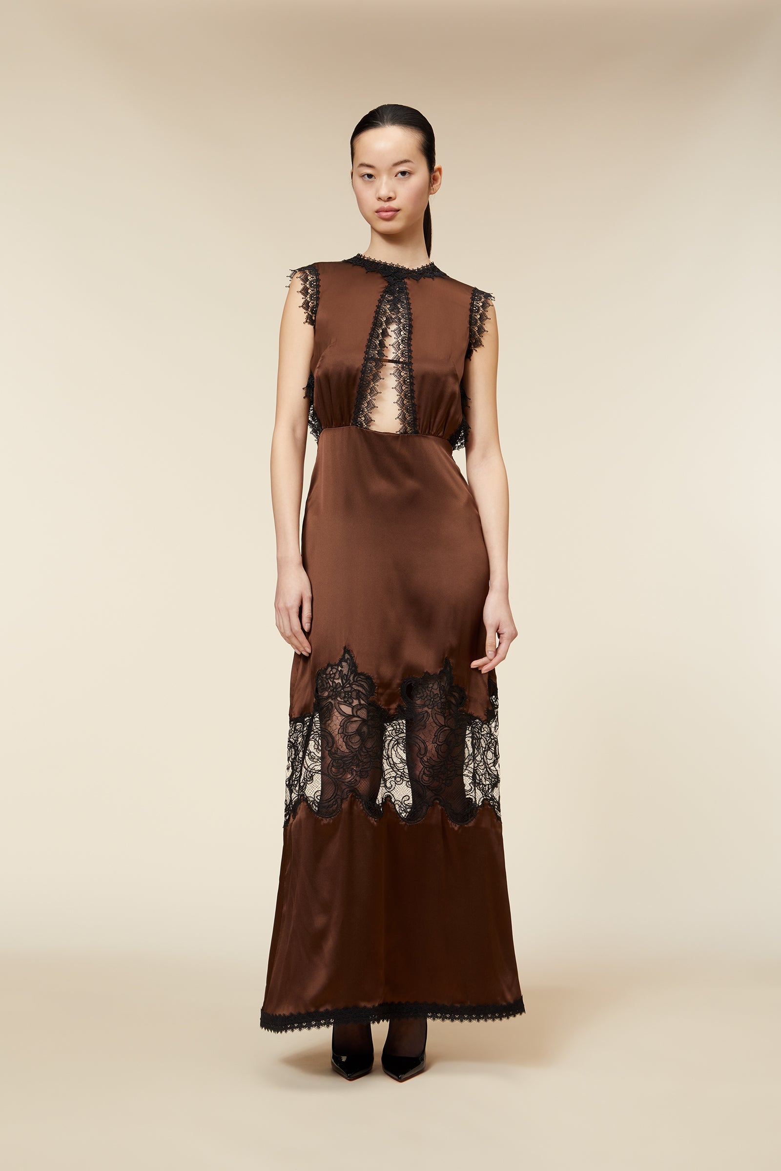 Elegant brown satin dress featuring intricate black lace accents and sheer panels, creating a sophisticated and modern look.