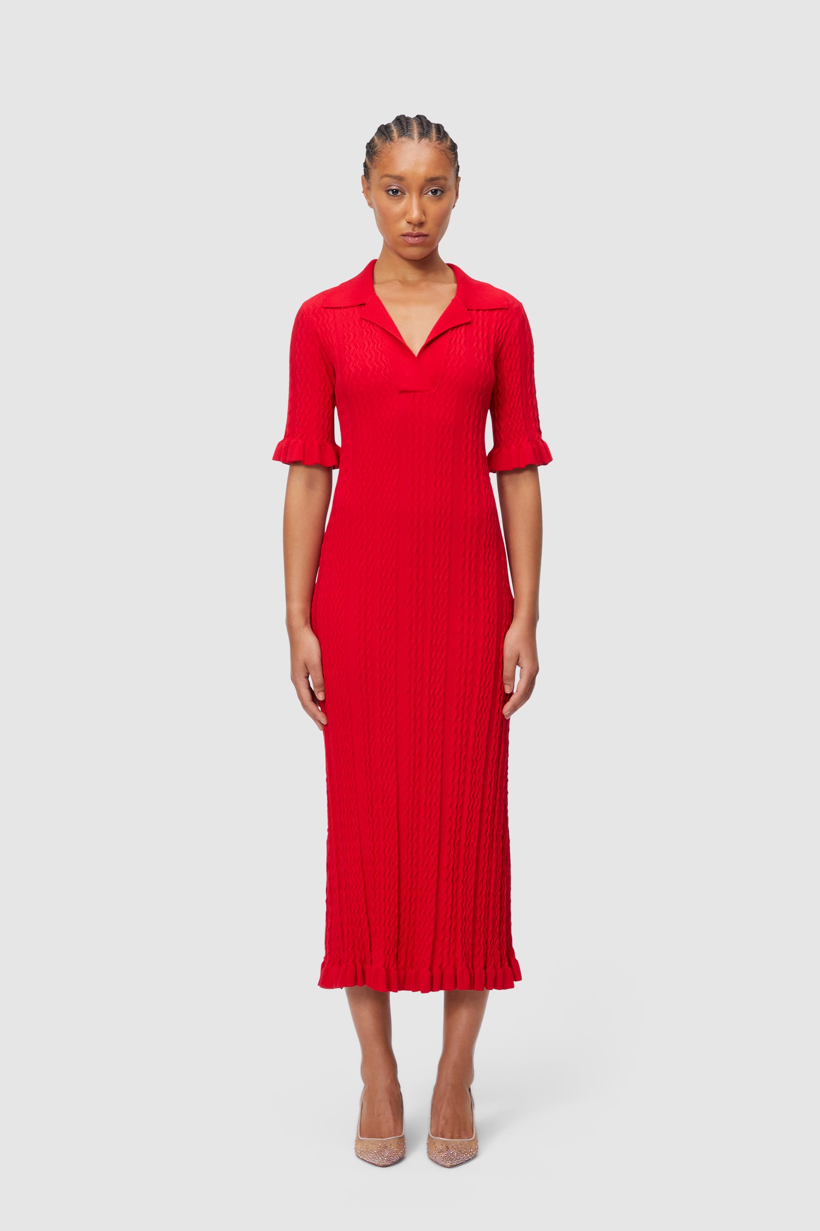 Elegant red knit dress features a collared neckline, three-quarter sleeves with ruffle cuffs, and a flowing knee-length hem.
