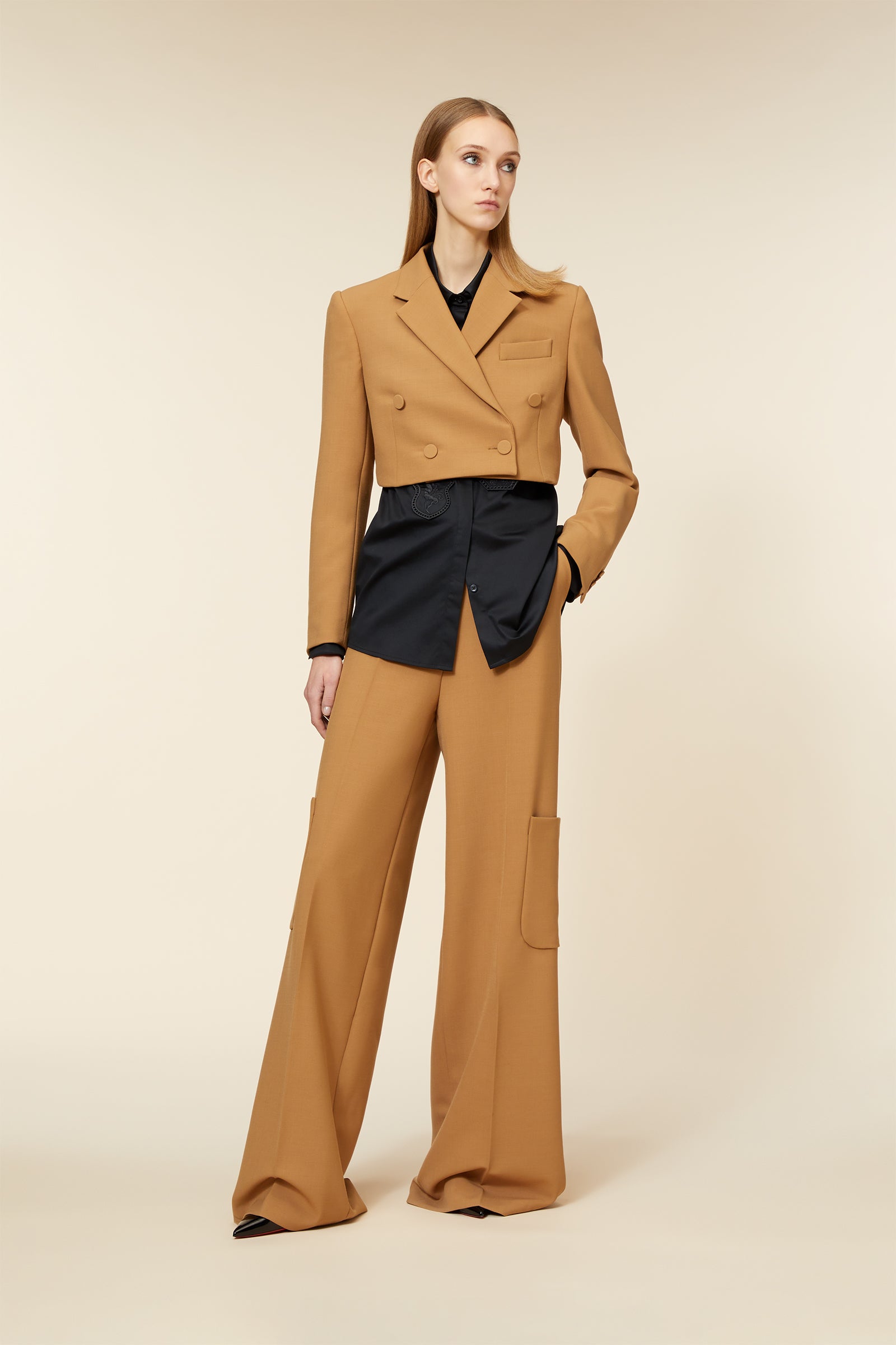 A tailored brown double-breasted blazer and matching wide-leg trousers with a modern black underlay detail.