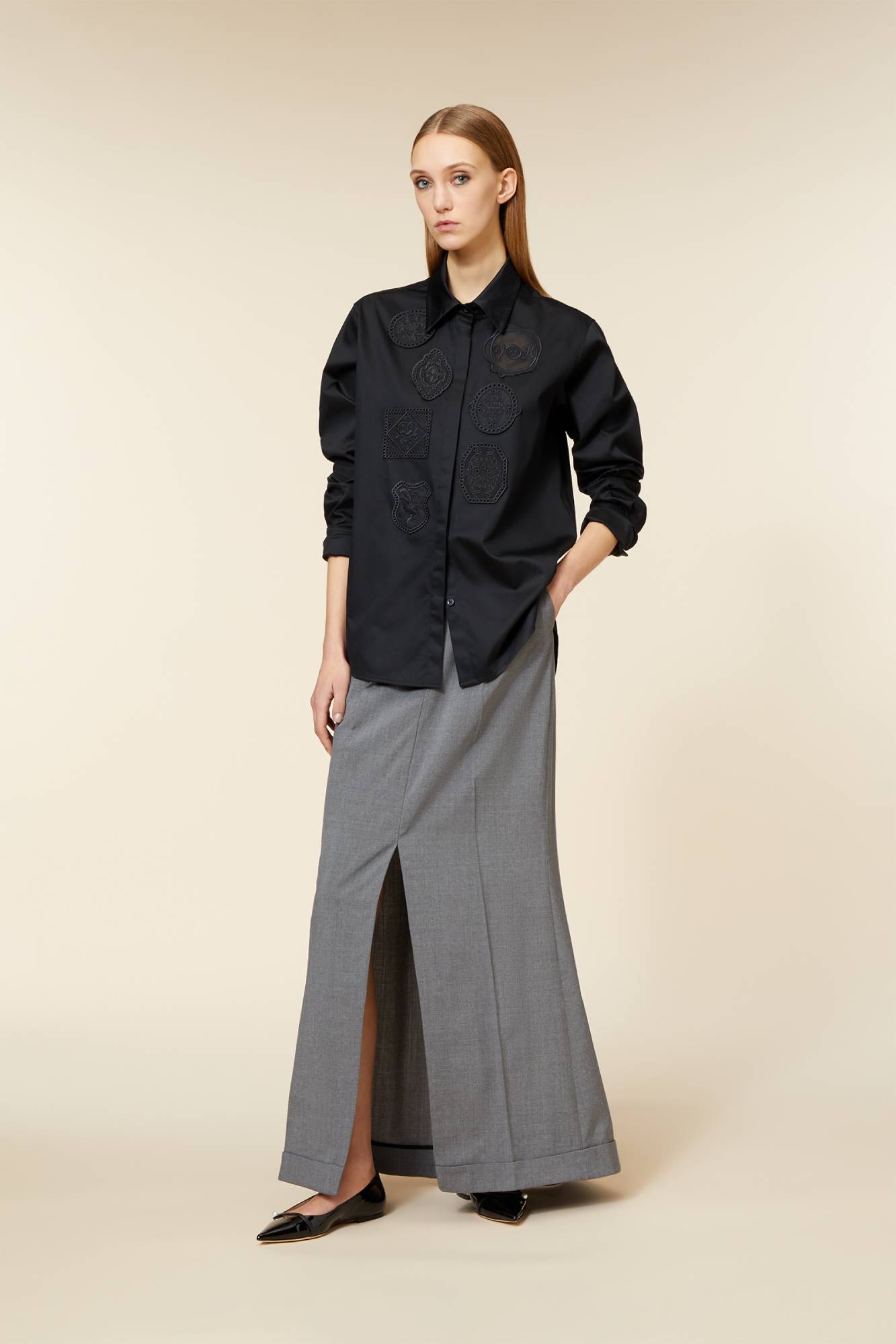 Elegant ensemble featuring a black button-up blouse with embossed patterns paired with a sleek grey maxi skirt with slit.