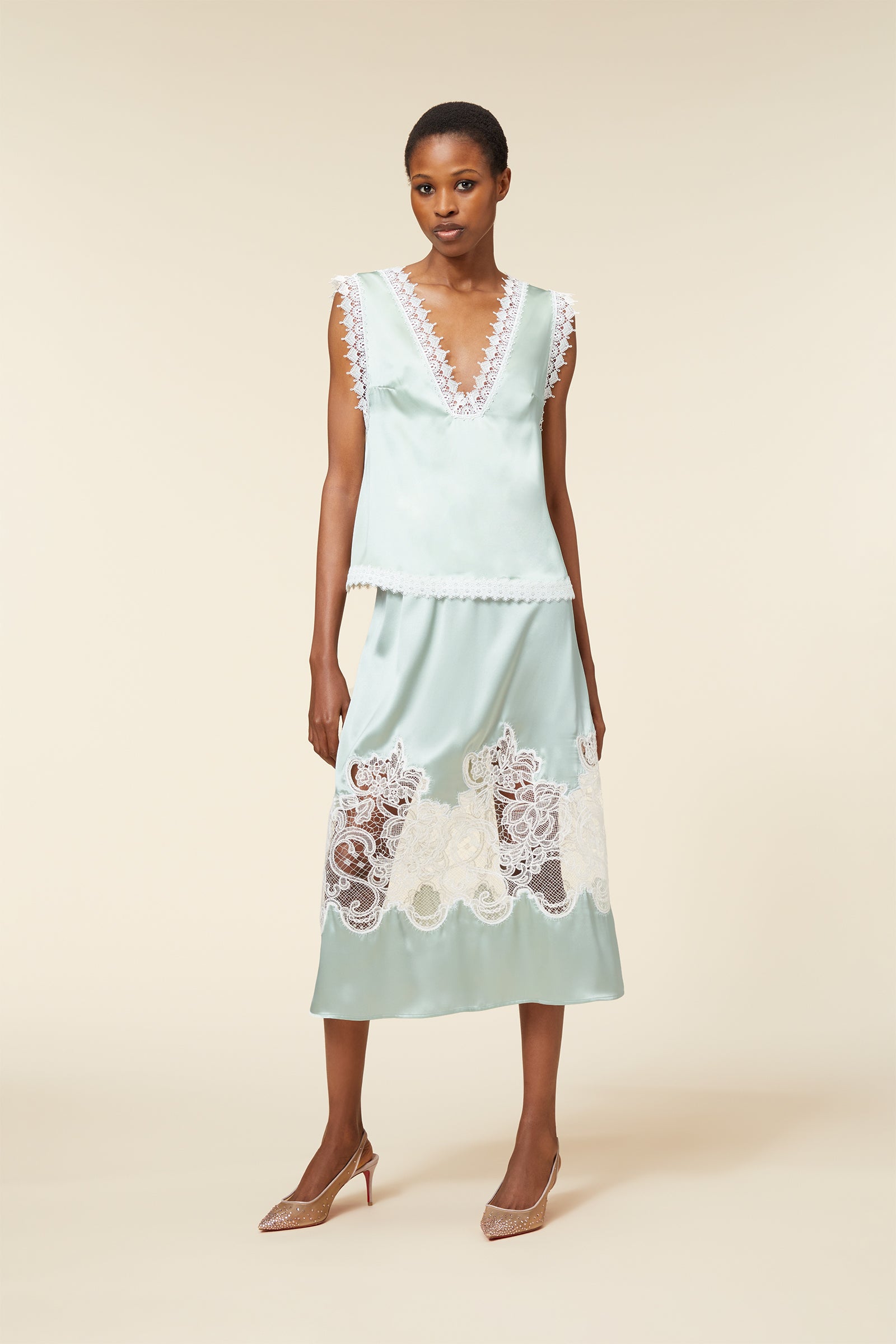 Elegant light green satin dress with intricate white lace detailing, featuring a deep V-neckline and scalloped hemline.