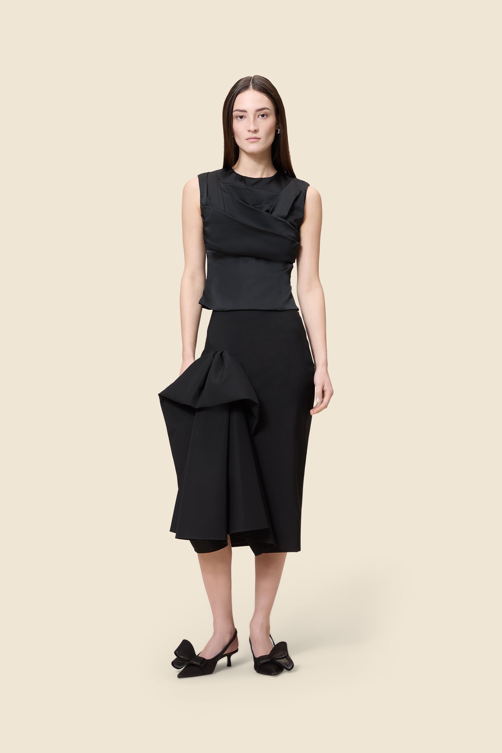 The meticulously placed pleats and stretch satin define the elegance of the top, reflecting classic haute couture craftsmanship with a modern edge