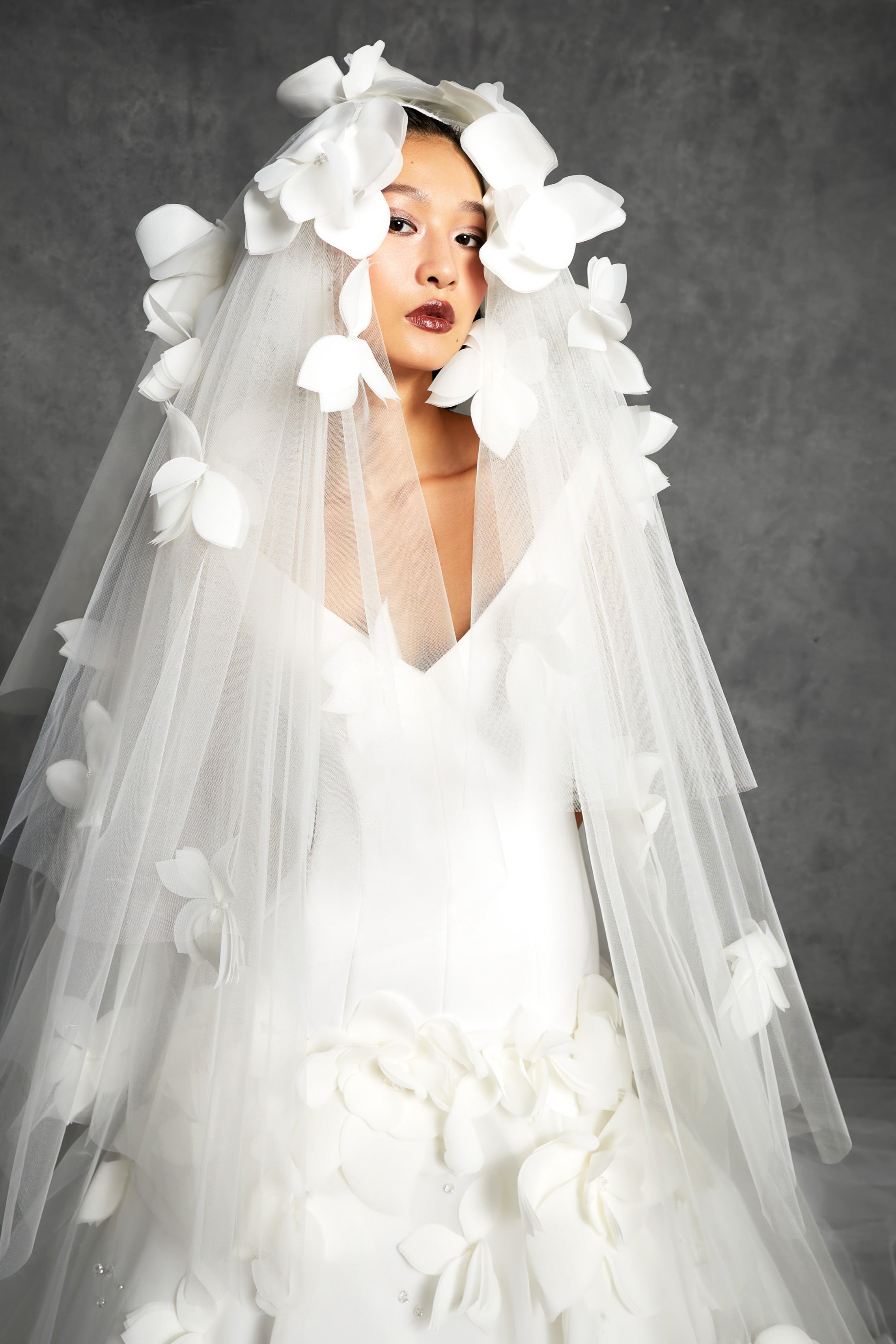 Tulle veil adorned with feathered airy organza flowers cascading down the sheer veil