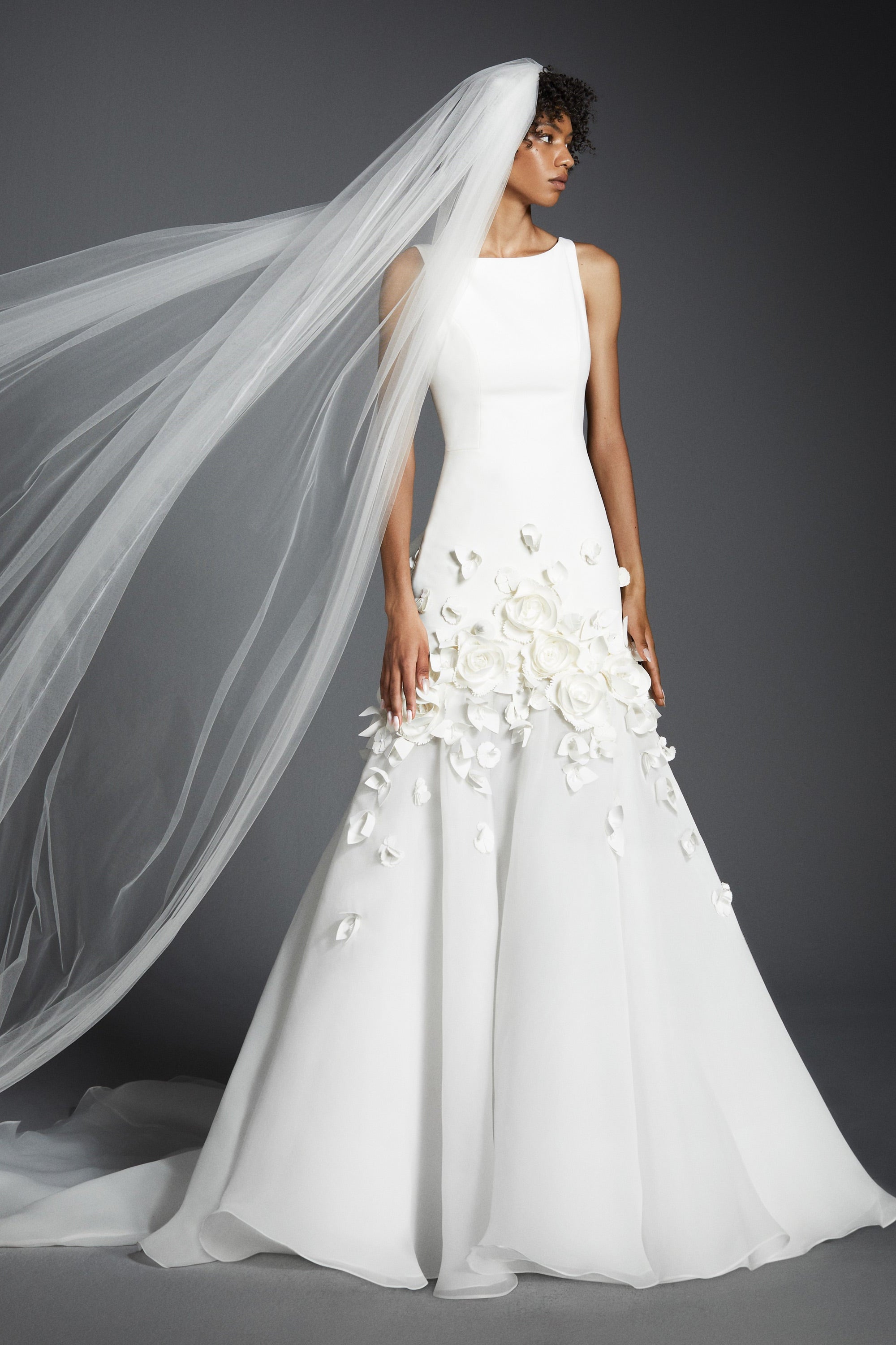 This refined mermaid gown, crafted from crepe with a slight stretch, perfectly molds to the wearer’s body before flaring out into a decadent train