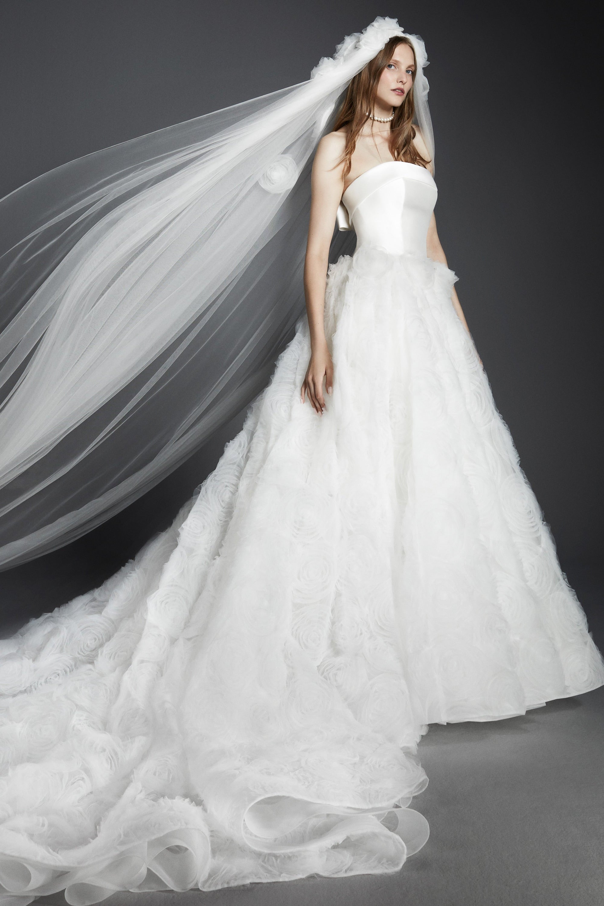 Delicate tulle roses gently descend along a dreamy and dramatic tulle veil