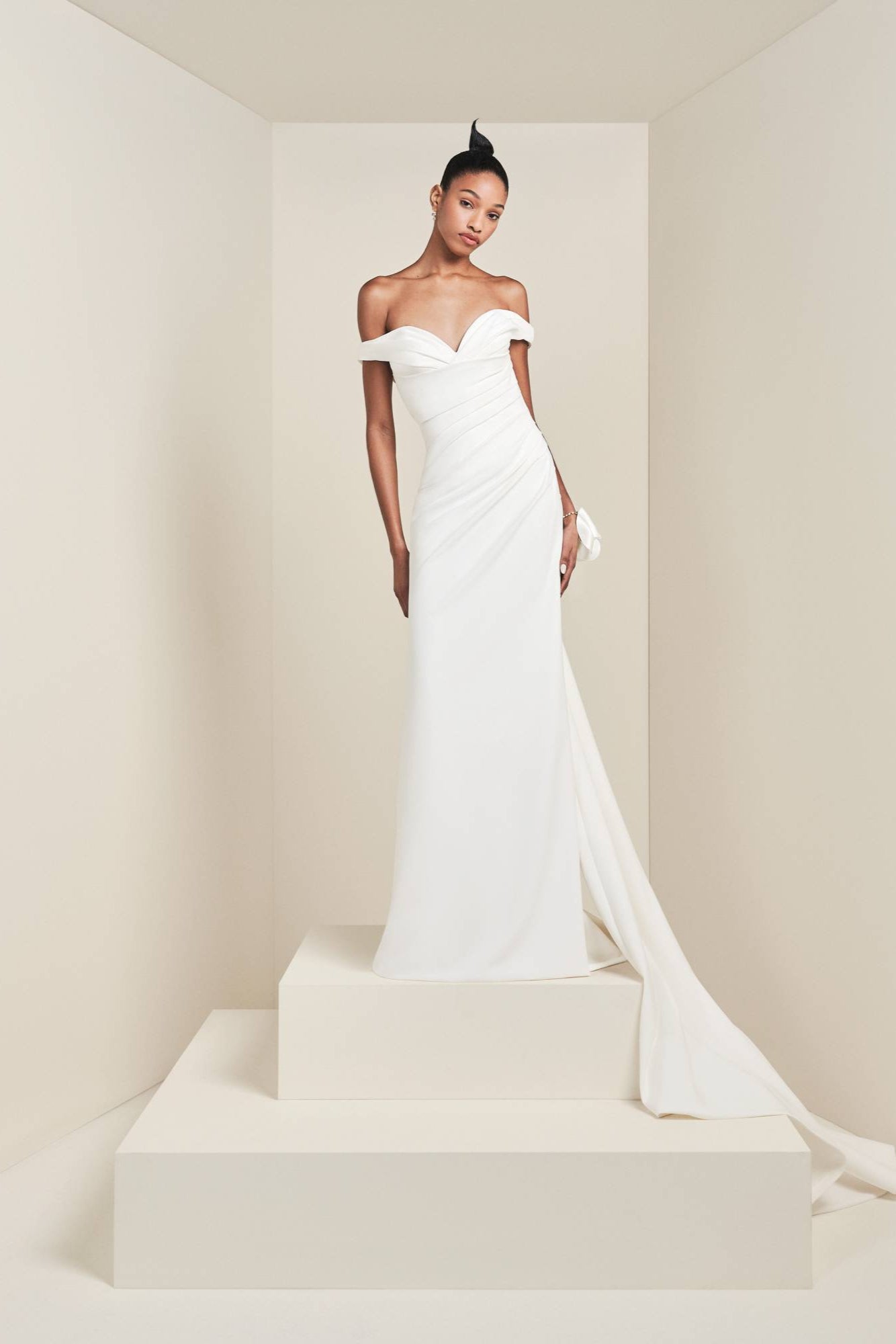 Crafted from crepe fabric with a slight stretch, this gown boasts a fitted bodice that transitions into a mermaid skirt