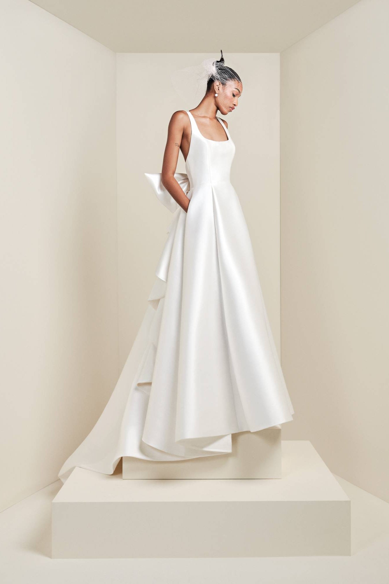 Crafted from luxurious mikado fabric, this a-line gown showcases a squared front neck-line and an inverted triangle at the back, adorned with a signature viktor&rolf bow that drapes into a diagonal fold volant