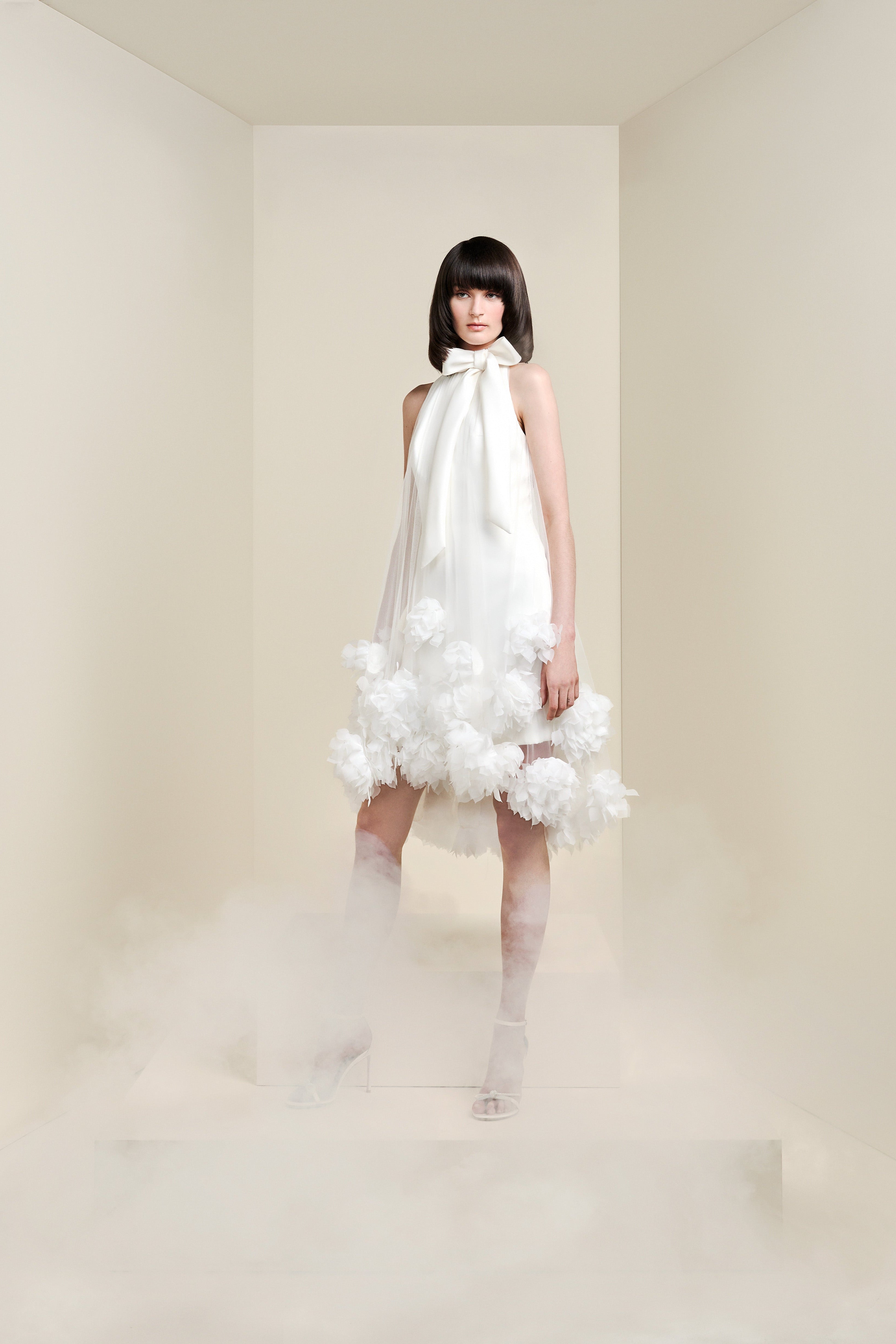 This short dress is crafted from matte satin fabric, overlaid with a romantic tulle sheath dress