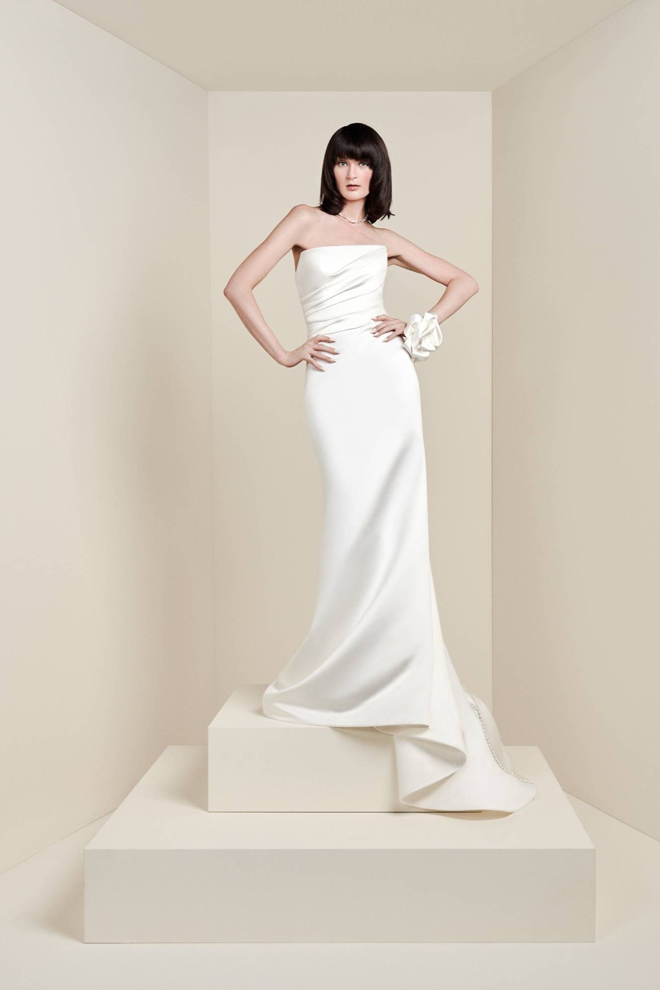 Crafted from satin fabric, this timeless gown features a modern draped strapless bodice with a fitting built-in corset