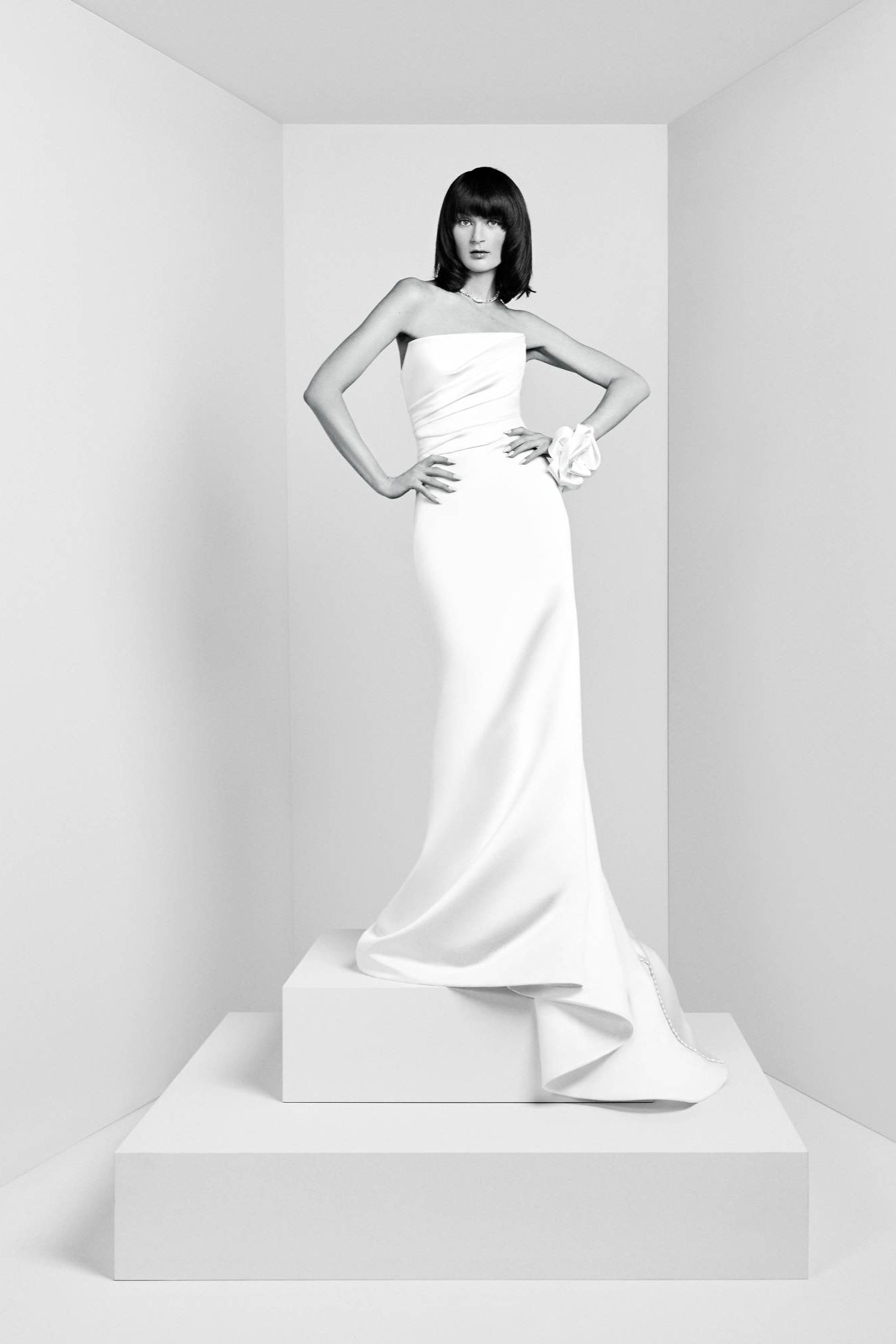 Crafted from satin fabric, this timeless gown features a modern draped strapless bodice with a fitting built-in corset