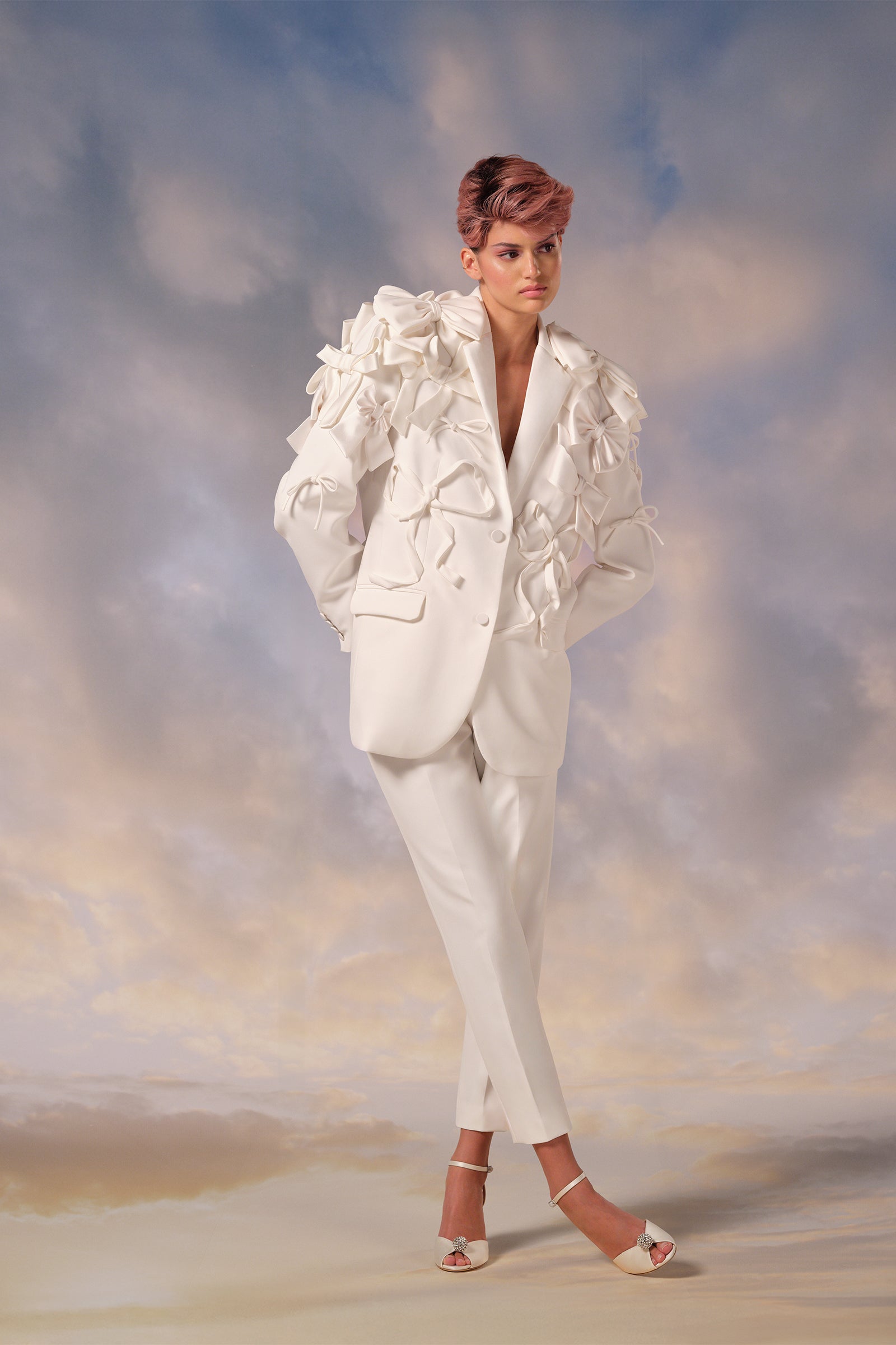 This tailored stretch crepe suit features a jacket with satin lapels forming an elegant v-neckline, paired with modern cigarette pants, from the Viktor&Rolf Mariage collection.