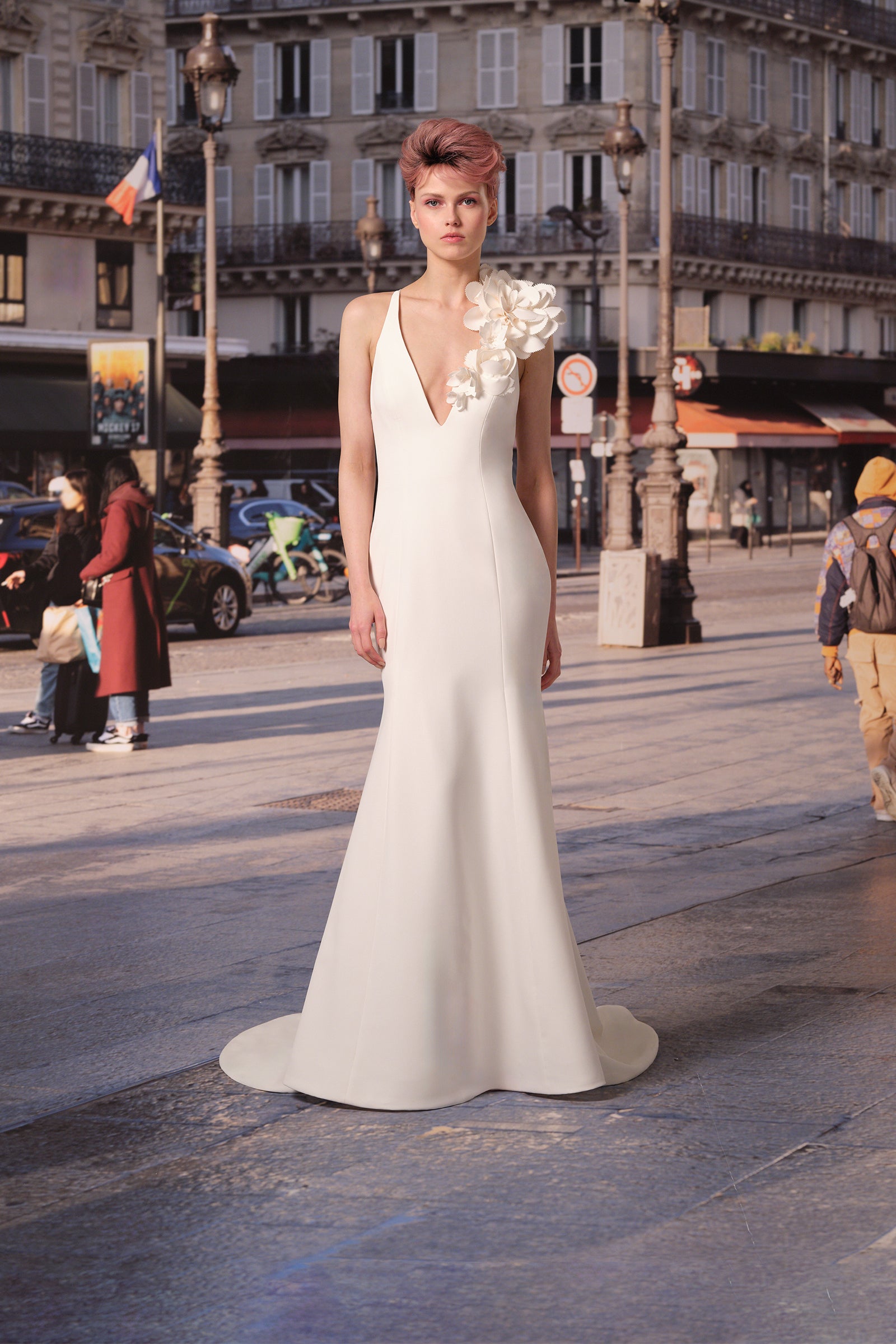 This stretch crepe mermaid gown features a striking plunging v-neck and open cross back adorned with delicate, handcrafted floral arrangements, from the Viktor&Rolf Mariage collection.