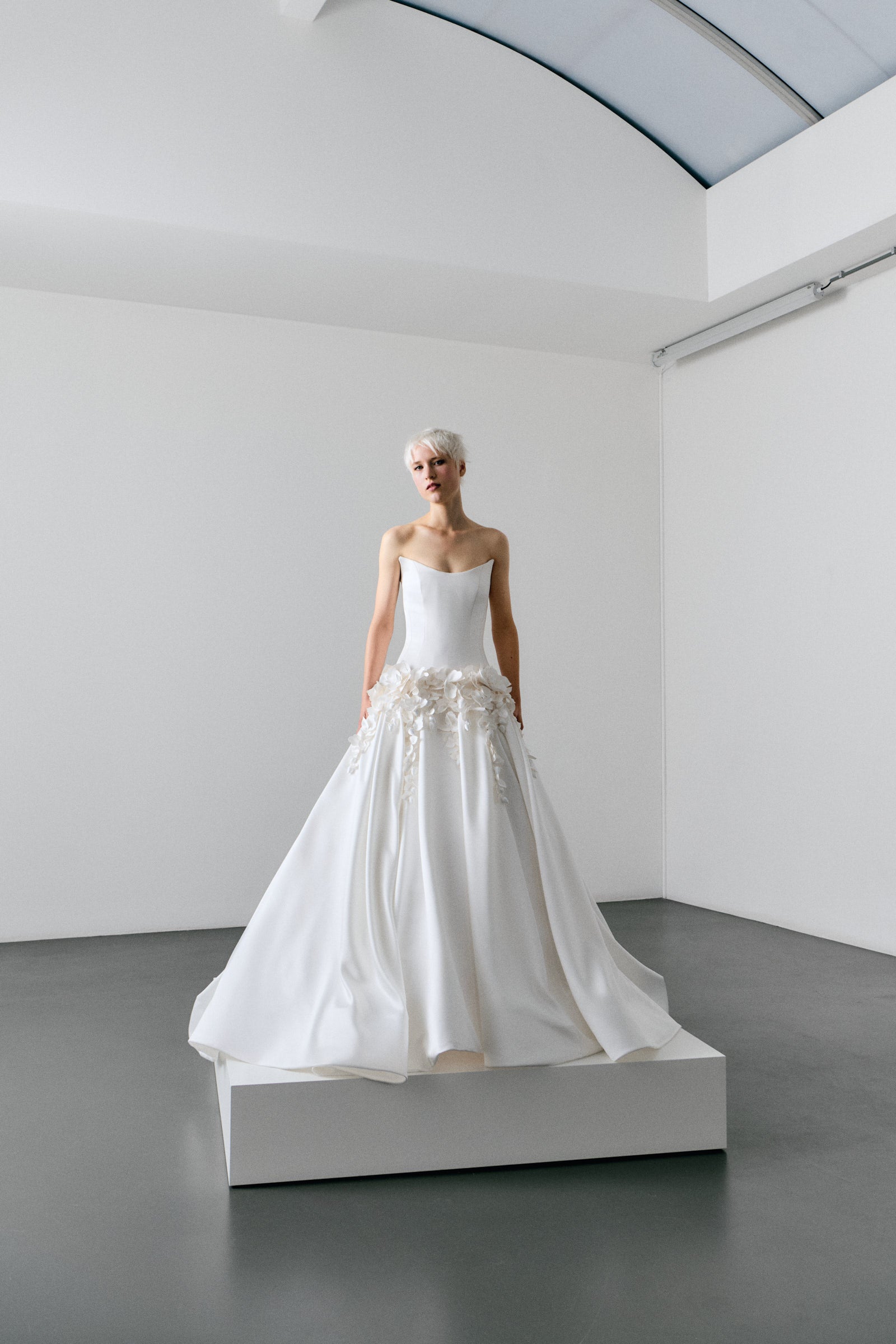 White wedding dress on a mannequin in a minimalistic room.