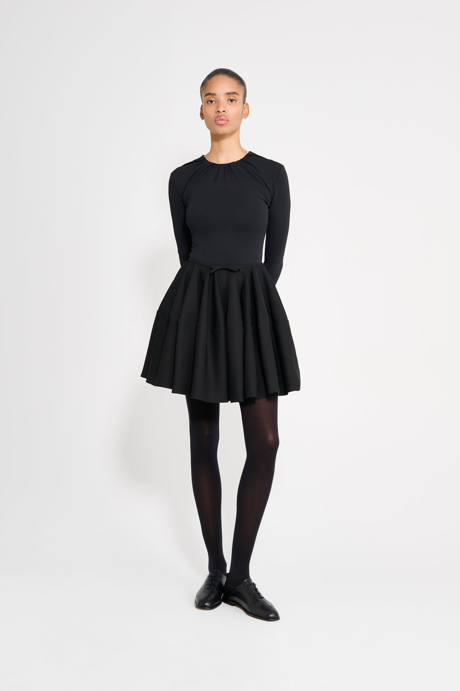 Person wearing a black dress with a white background