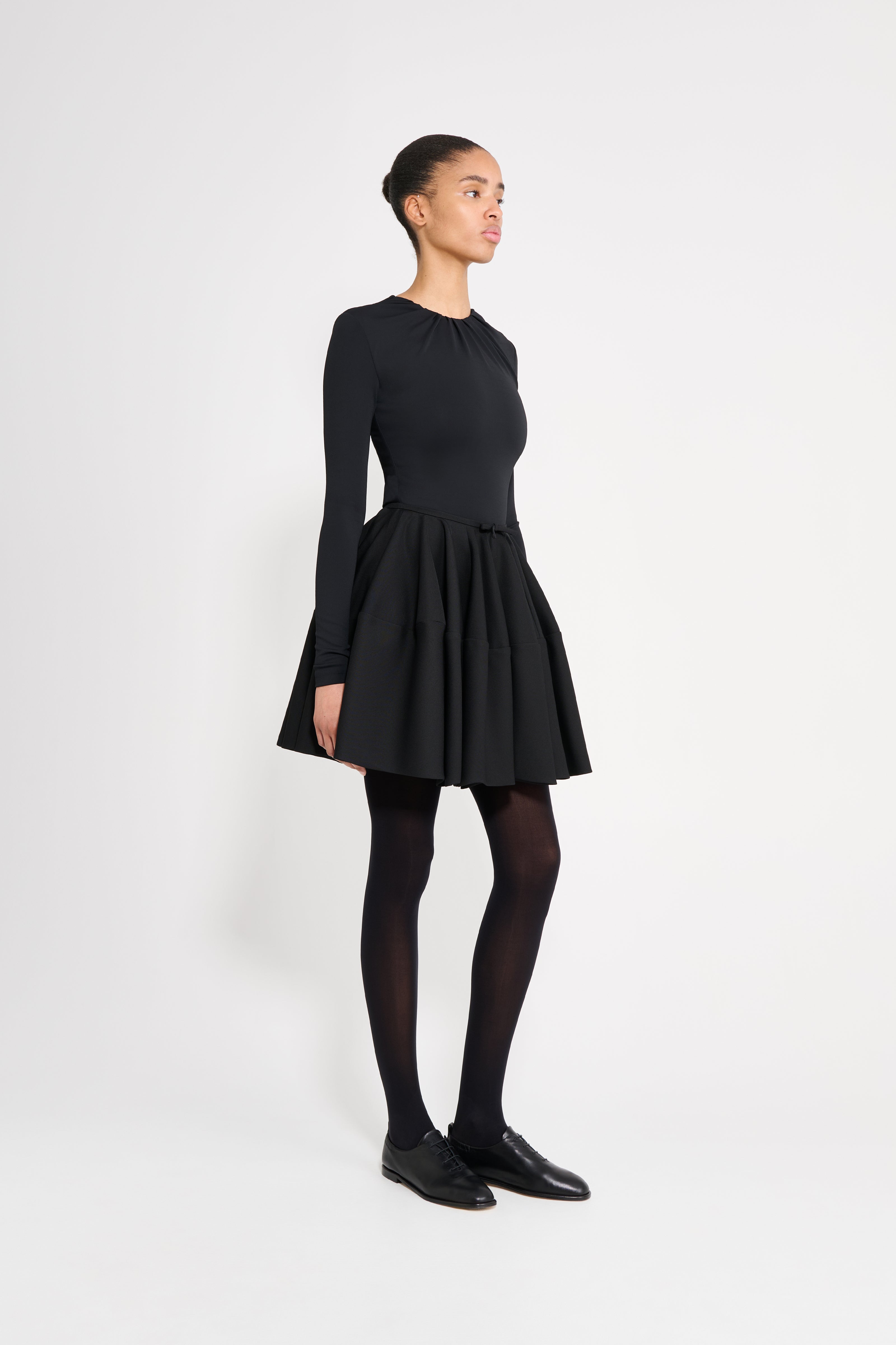 Person wearing a black dress on a white background