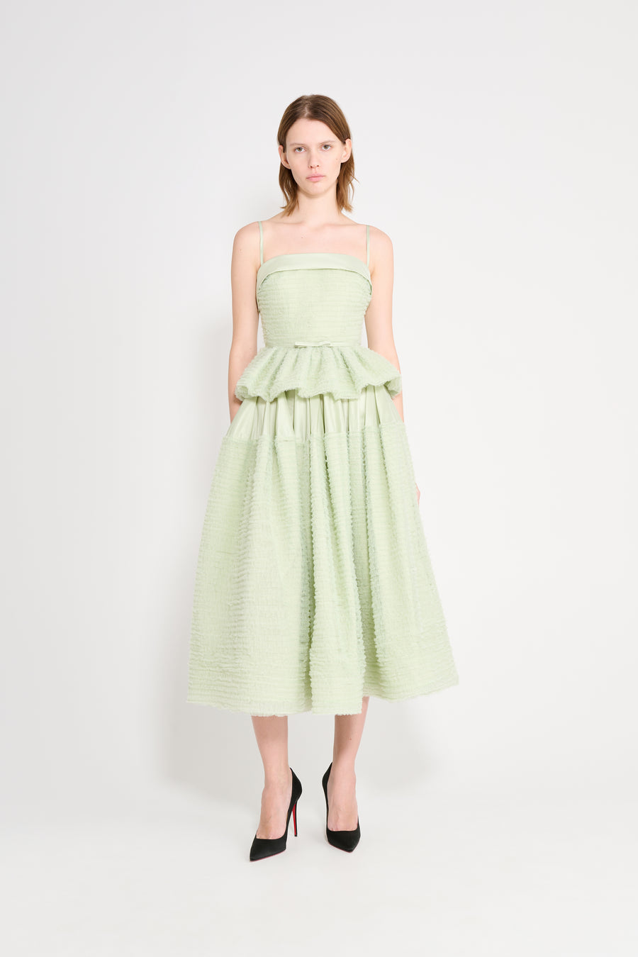 Woman wearing a light green dress on a white background