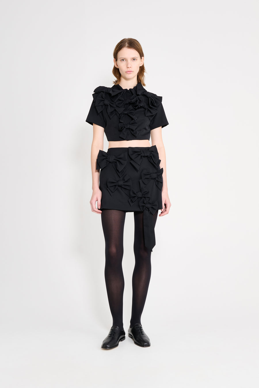 The wool skirt features the seasonal bow bouquet technique, where timeless elegance meets refined craftsmanship in a seamless fusion of sophistication and grace