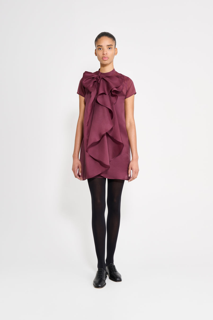 Model wearing a dress with a bow in the "Berry" color.