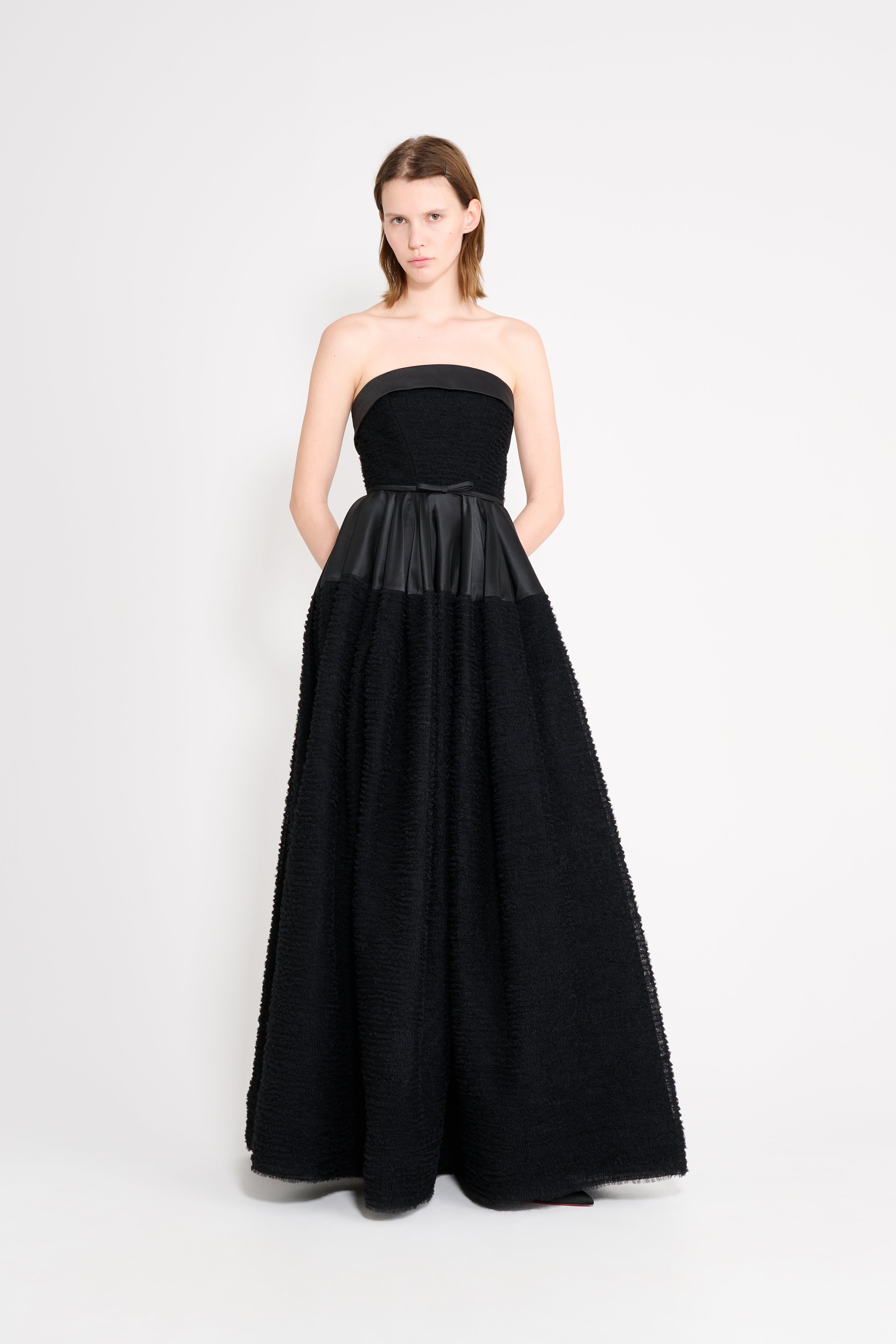 Model wearing a black strapless gown.