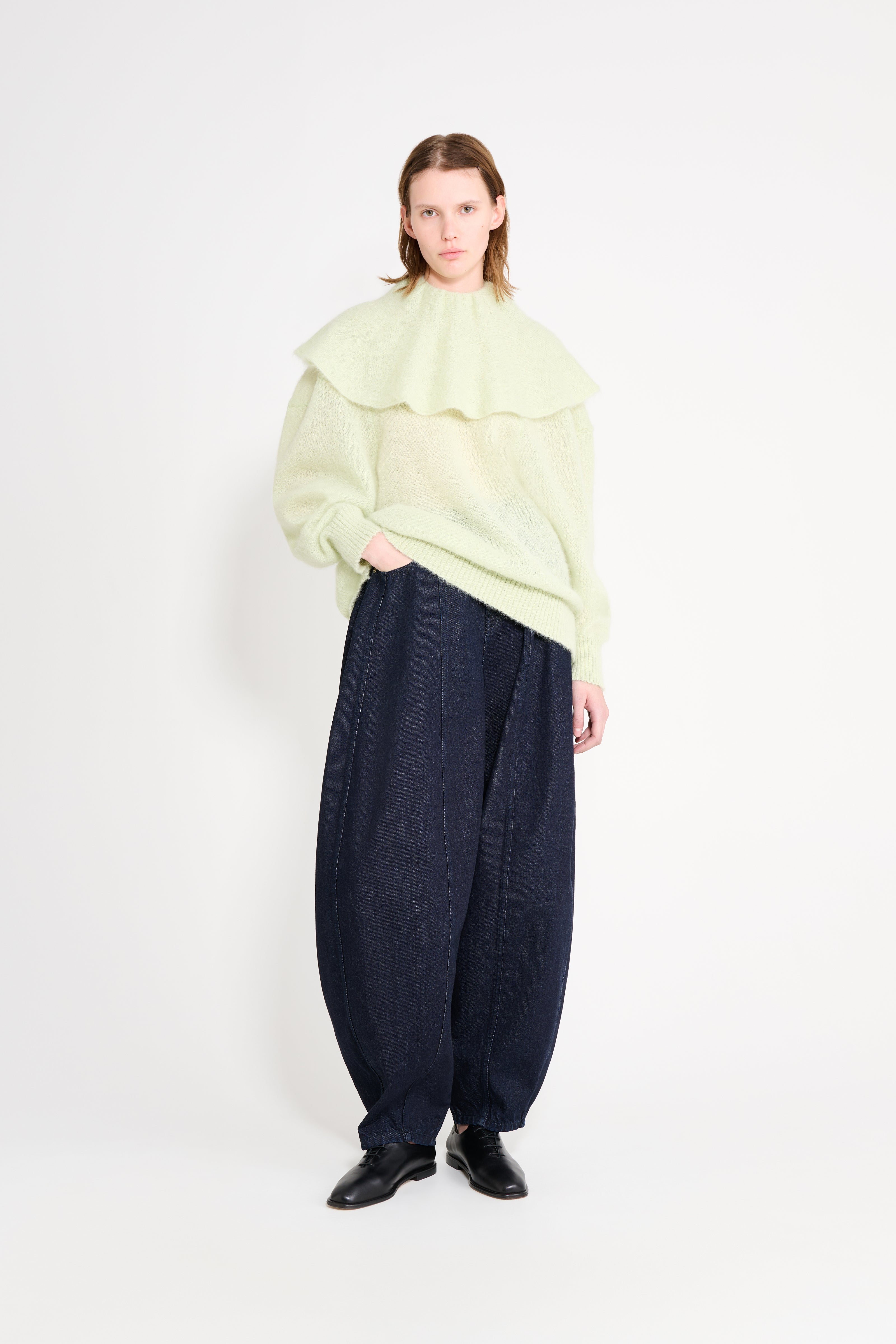 Model wearing a mint volant neck sweater.